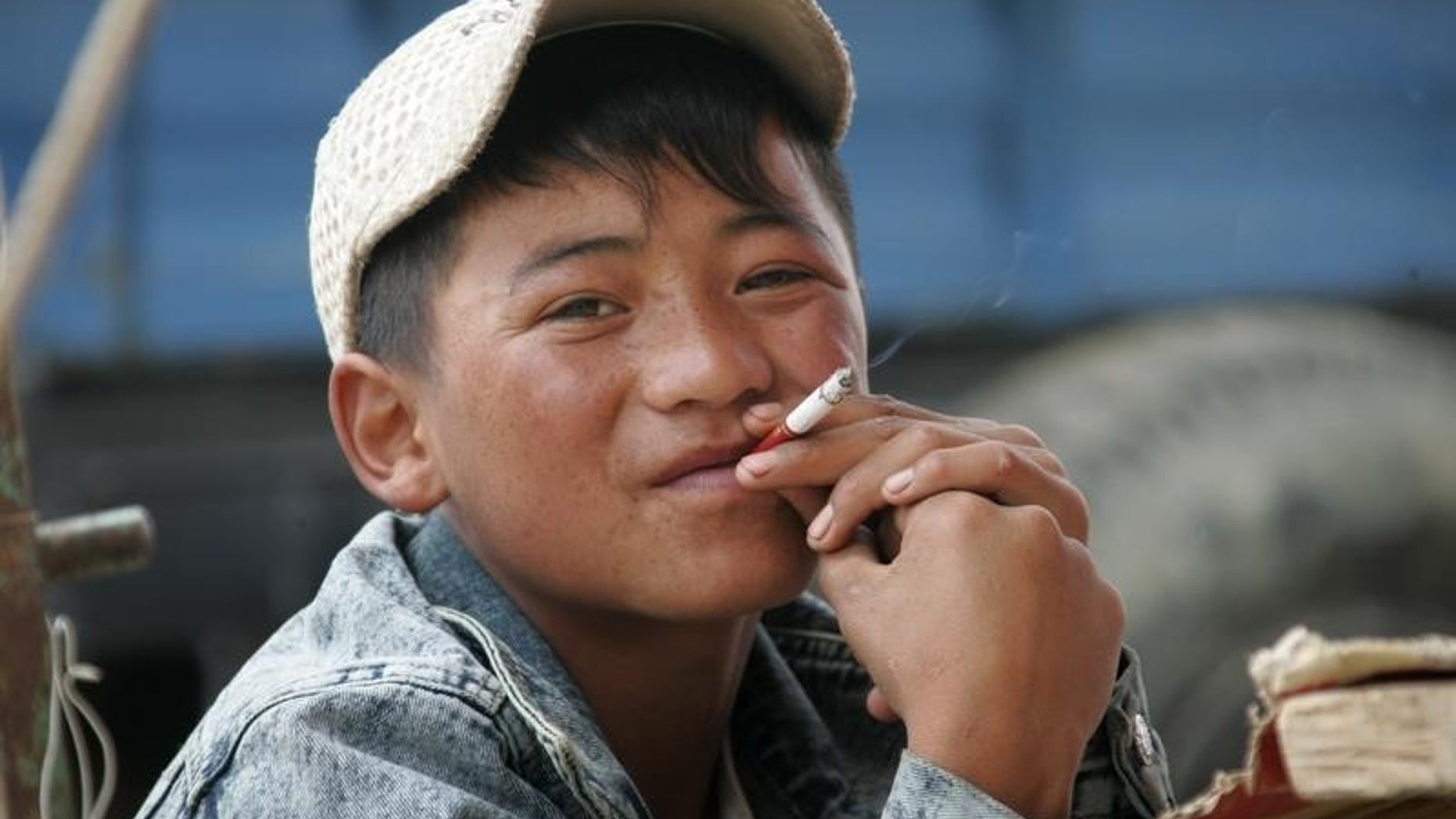 A 16-year-old Tibetan boy smokes in Dangxiong country, Tibet, June 29, 2006. REUTERS/Jason Lee