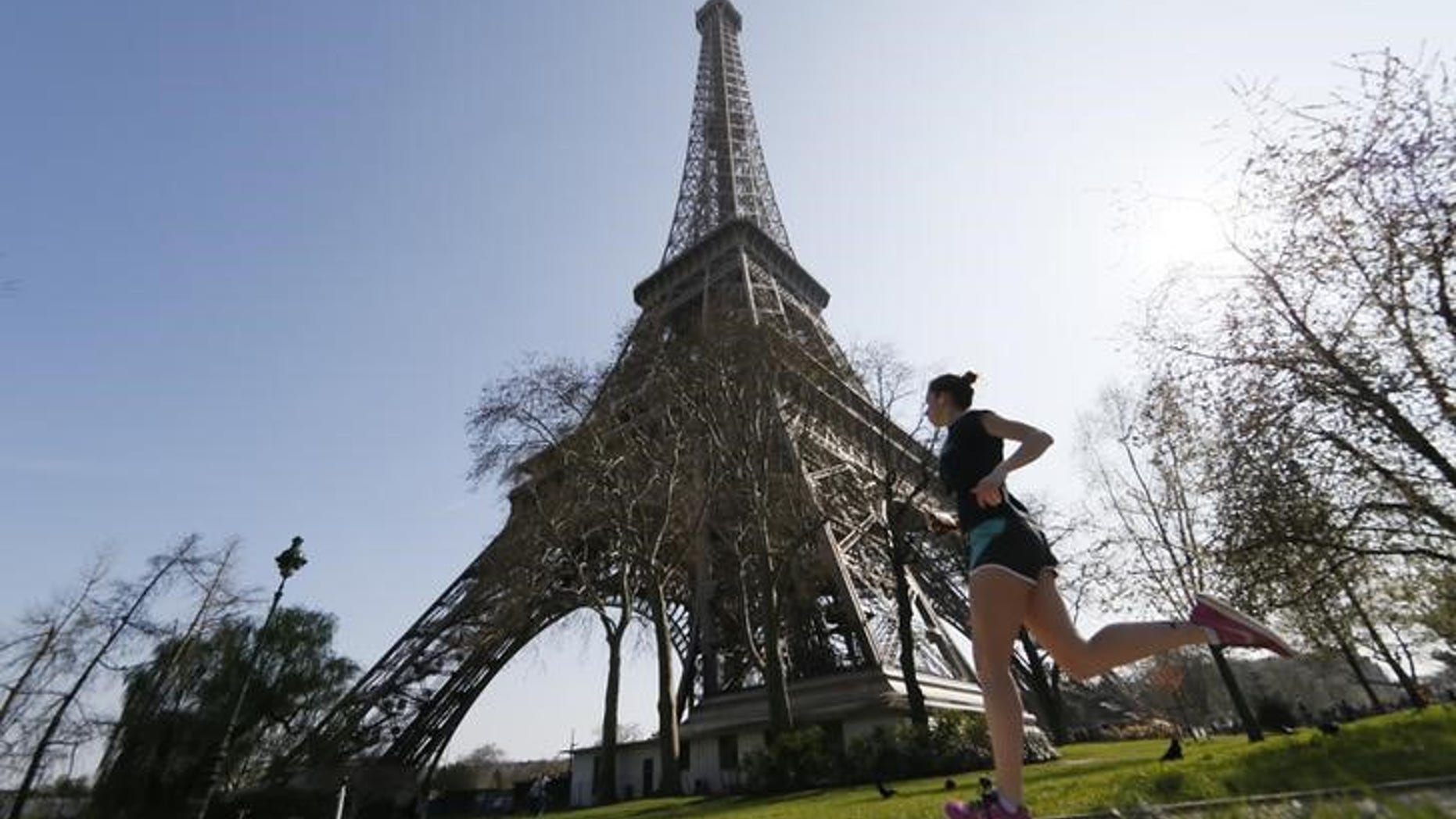 A jogger enjoys a run near the Eiffel Tower on a warm and sunny day in Paris April 8, 2015. REUTERS/Gonzalo Fuentes