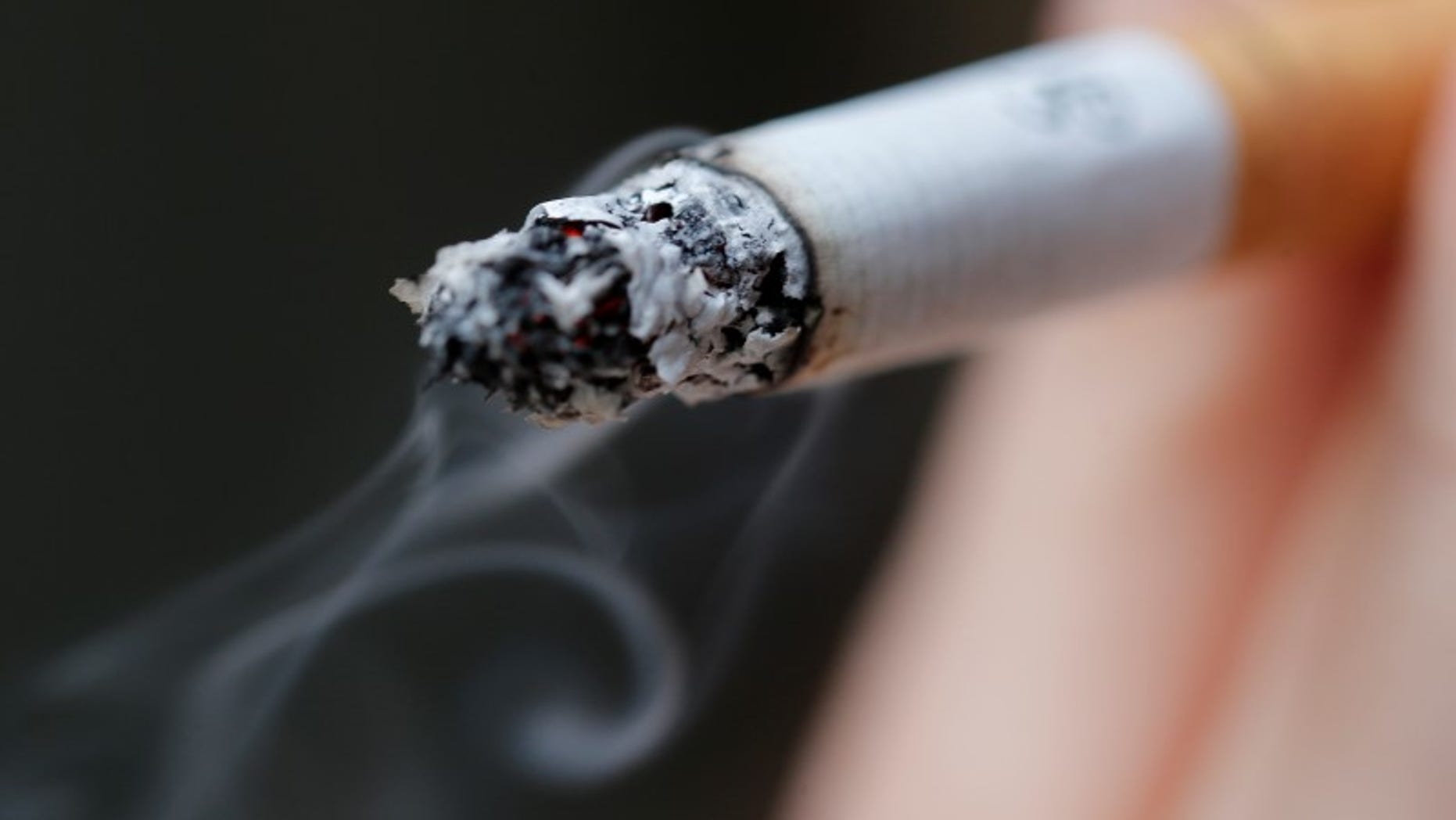 A woman smokes a cigarette in this illustration picture taken in Paris, October 8, 2014. REUTERS/Christian Hartmann