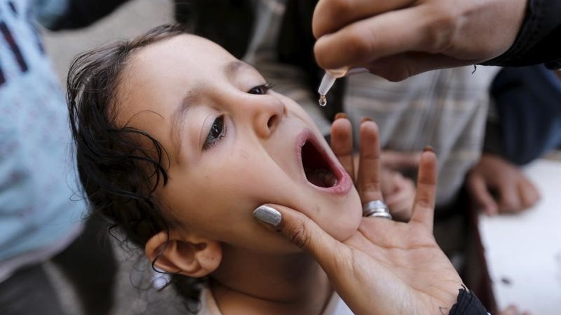 A girl receives polio vaccine drops at a school in Sanaa sheltering people after conflict forced them to flee their homes in Yemen's Houthi-controlled northern province of Saada August 15, 2015. REUTERS/Khaled Abdullah