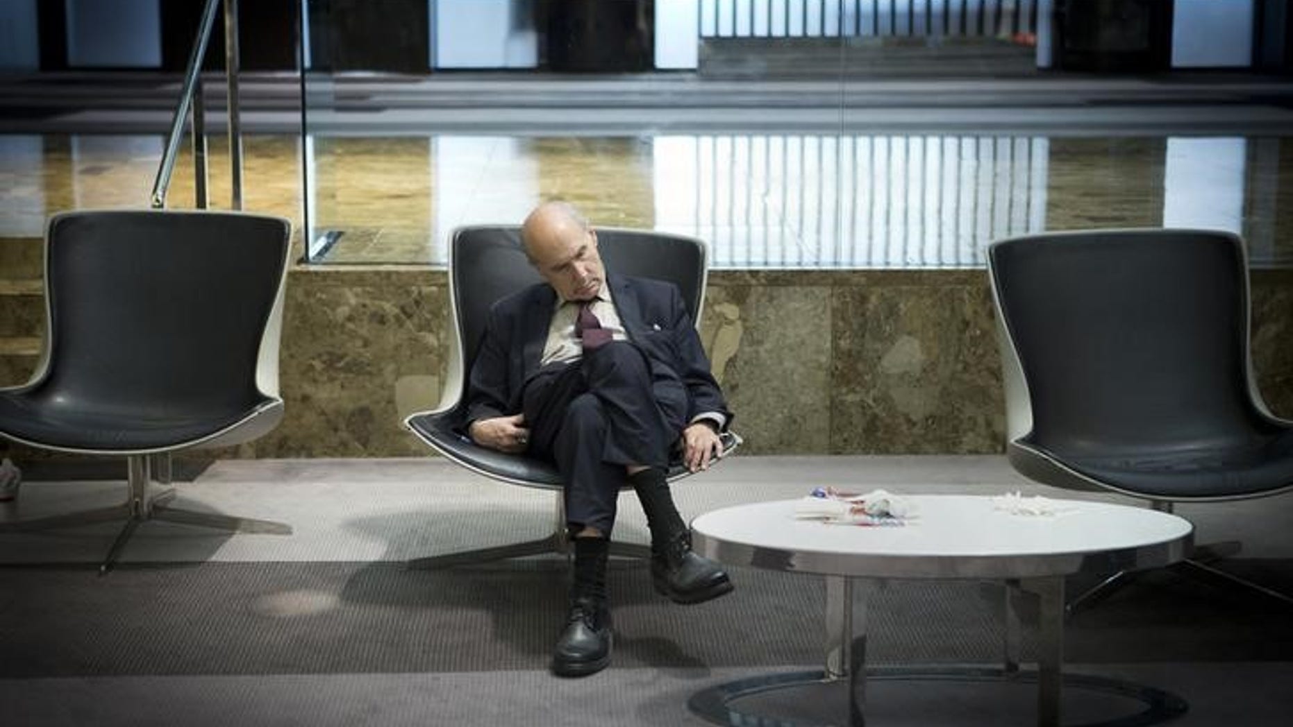 A businessman takes a mid-day nap in the lobby of a midtown hotel in the Manhattan borough of New York August 1, 2014. REUTERS/Carlo Allegri