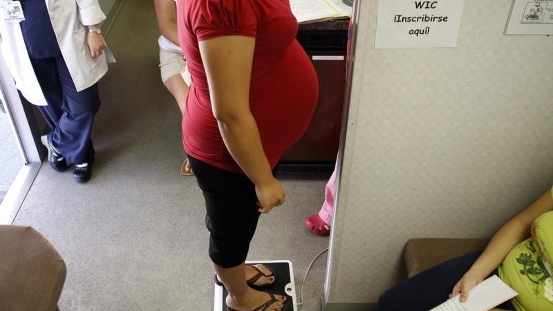 A pregnant woman stands on a scale before receiving a prenatal exam at the Maternity Outreach Mobile in Phoenix, Arizona October 8, 2009. REUTERS/Joshua Lott