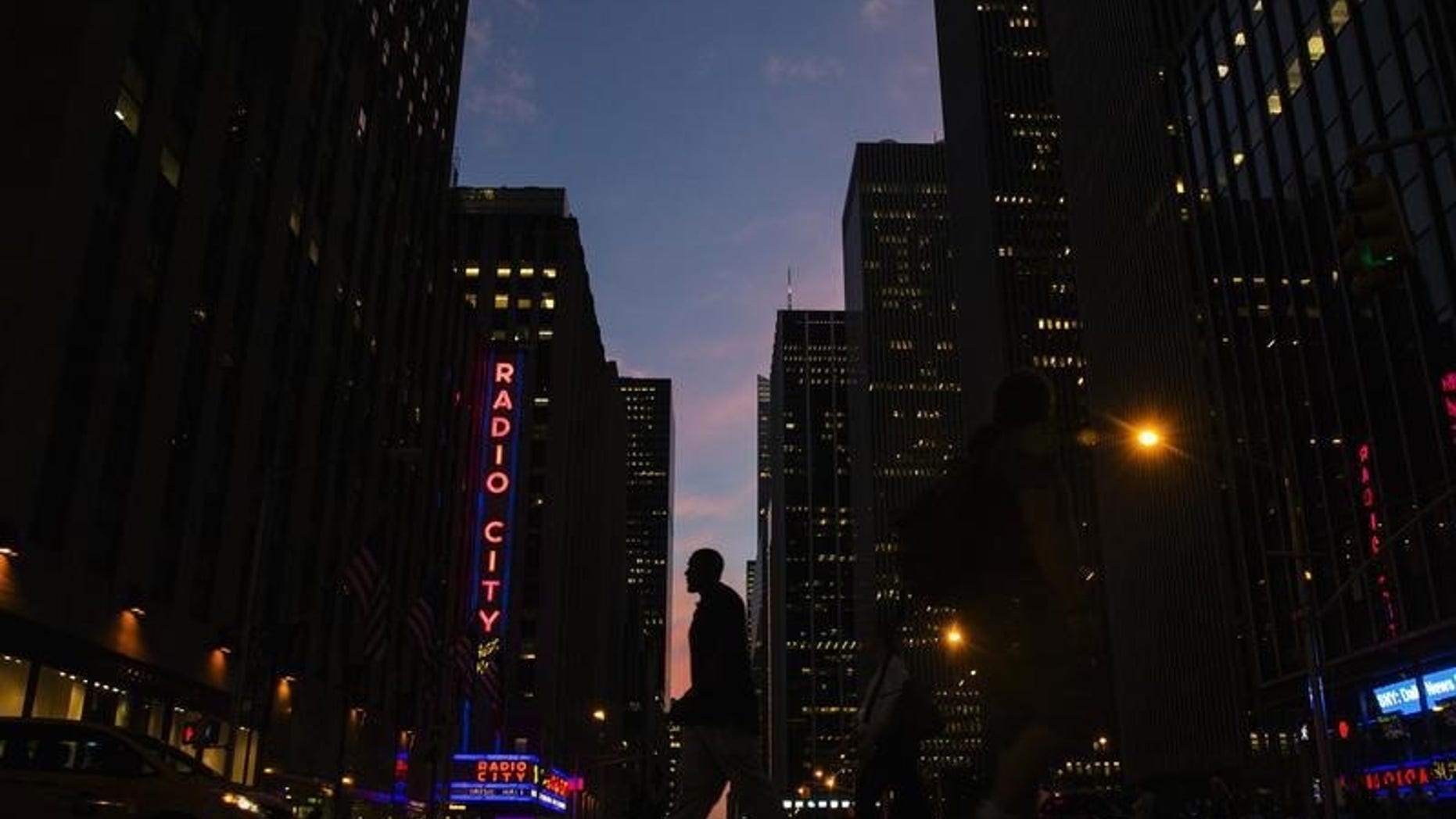 A man crosses 6th Avenue as the sun sets in New York September 3, 2014. REUTERS/Lucas Jackson