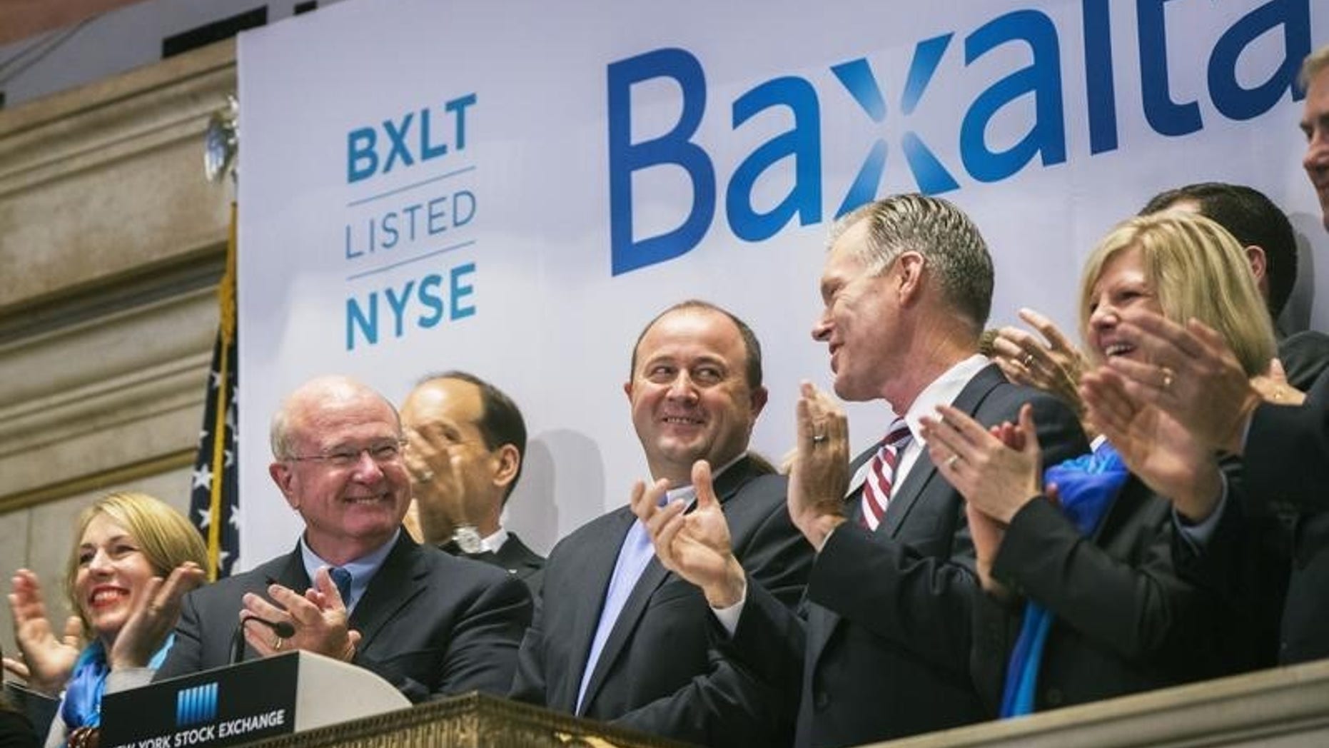 Ludwig Hantson (C), Chief Executive Officer of Baxalta, celebrates the company's IPO after ringing the opening bell above the floor of the New York Stock Exchange, July 1, 2015. REUTERS/Lucas Jackson