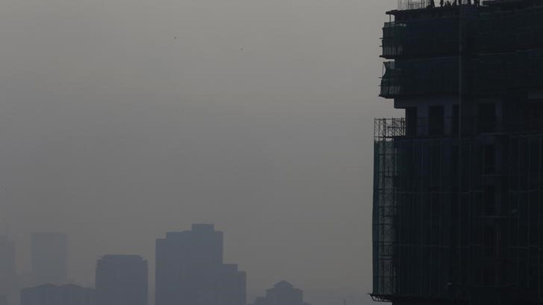 Builders work on hazy day in Kuala Lumpur, Malaysia, October 8, 2015. REUTERS/Olivia Harris
