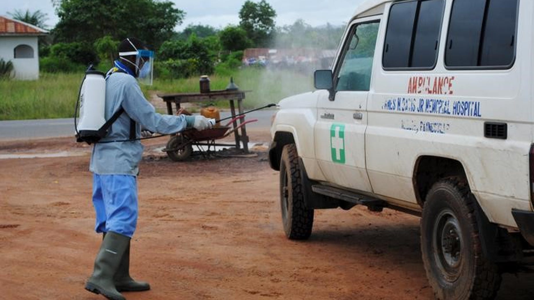 A health worker sprays disinfectant on an ambulance in Nedowein, Liberia, July 15, 2015. REUTERS/James Giahyue