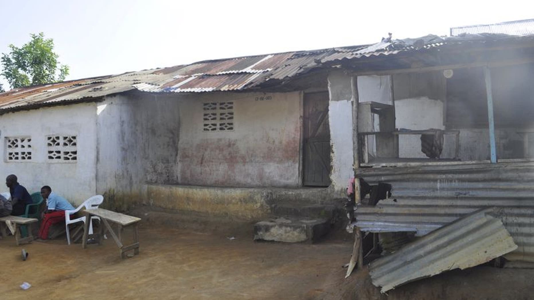 File photo of men sitting in front of a house where Ebola victim Nathan Gbotoe lived, in Paynesville, Liberia, November 24, 2015. REUTERS/James Giahyue