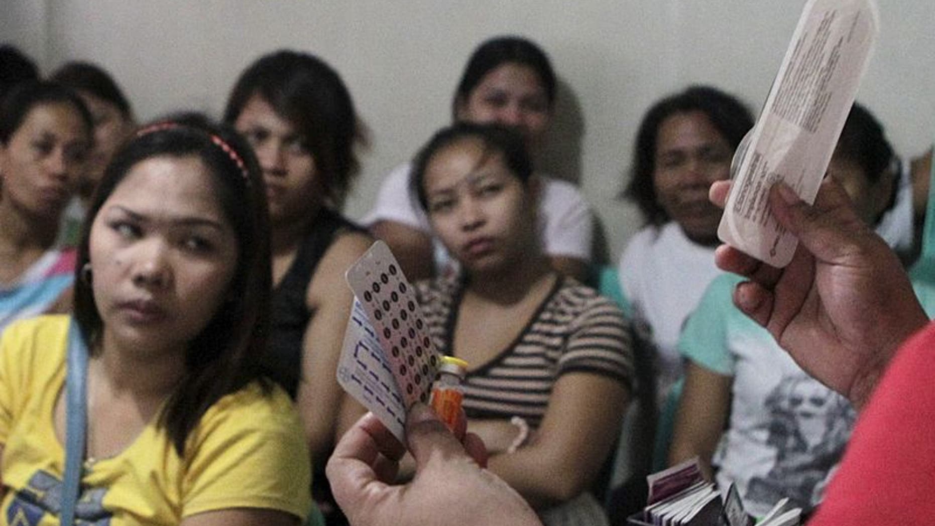 A community health worker holds up contraceptives during a lecture on family planning at a reproductive health clinic run by an Non-Governmental Organization (NGO) in Manila January 12, 2016. REUTERS/Janis Alano