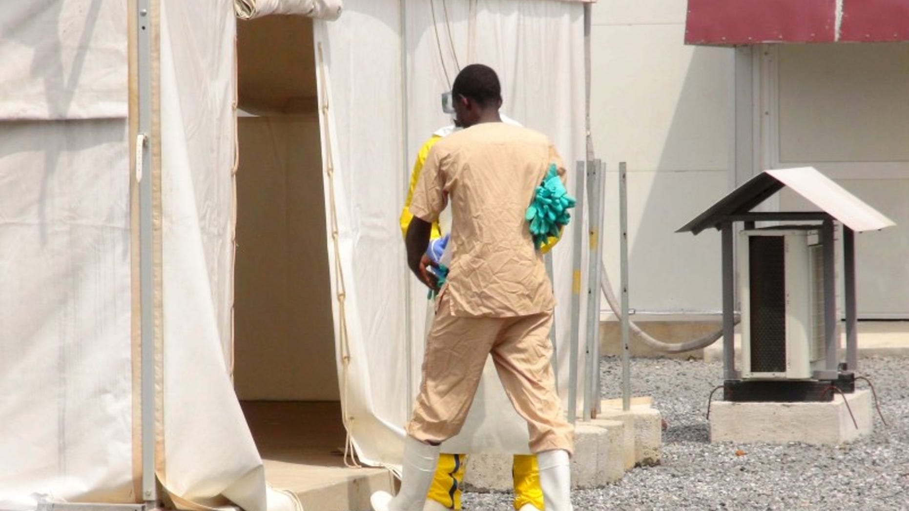 A health worker enters a tent in an Ebola virus treatment center in Conakry, Guinea, November 17, 2015. REUTERS/Saliou Samb