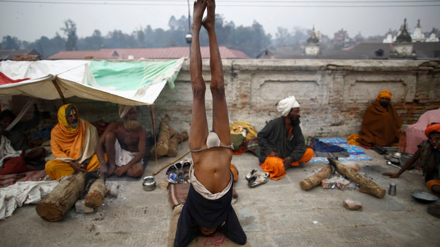 A Hindu holy man, or sadhu, performs yoga at the premises of Pashupatinath Temple in Kathmandu February 26, 2014. REUTERS/Navesh Chitrakar
