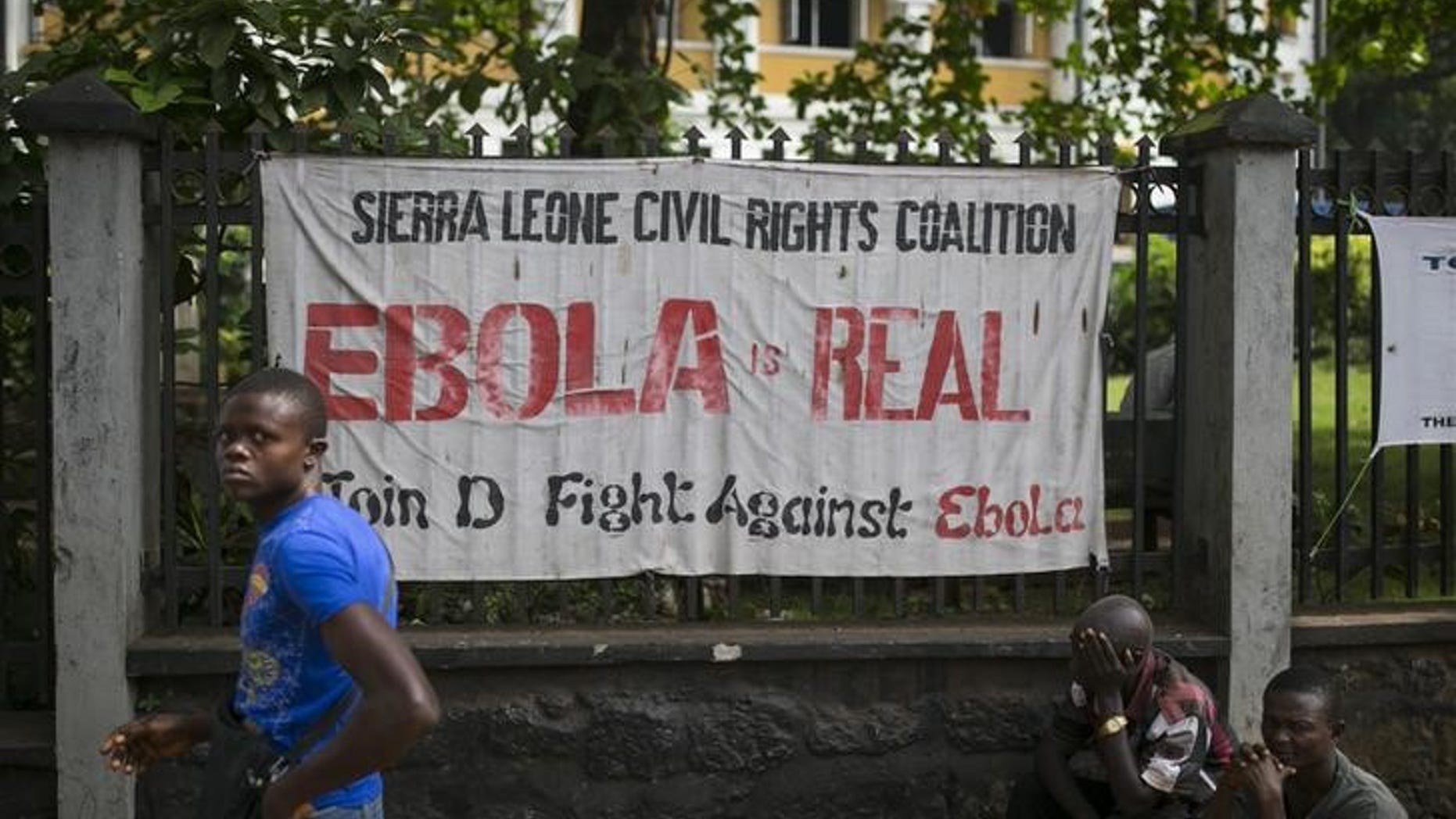 A man walks past a banner about Ebola in Freetown, Sierra Leone, in this December 16, 2014 file photo. REUTERS/Baz Ratner