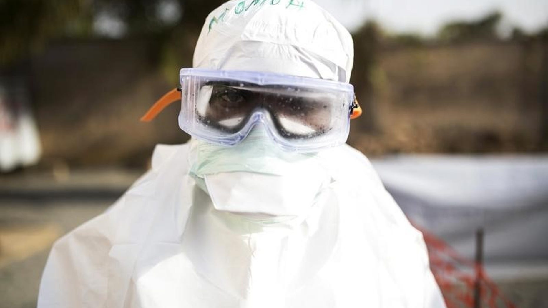 A health worker wearing protective gear stands outside a quarantine zone in a Red Cross facility in the town of Koidu, Kono district in Eastern Sierra Leone December 18, 2014. REUTERS/Baz Ratner