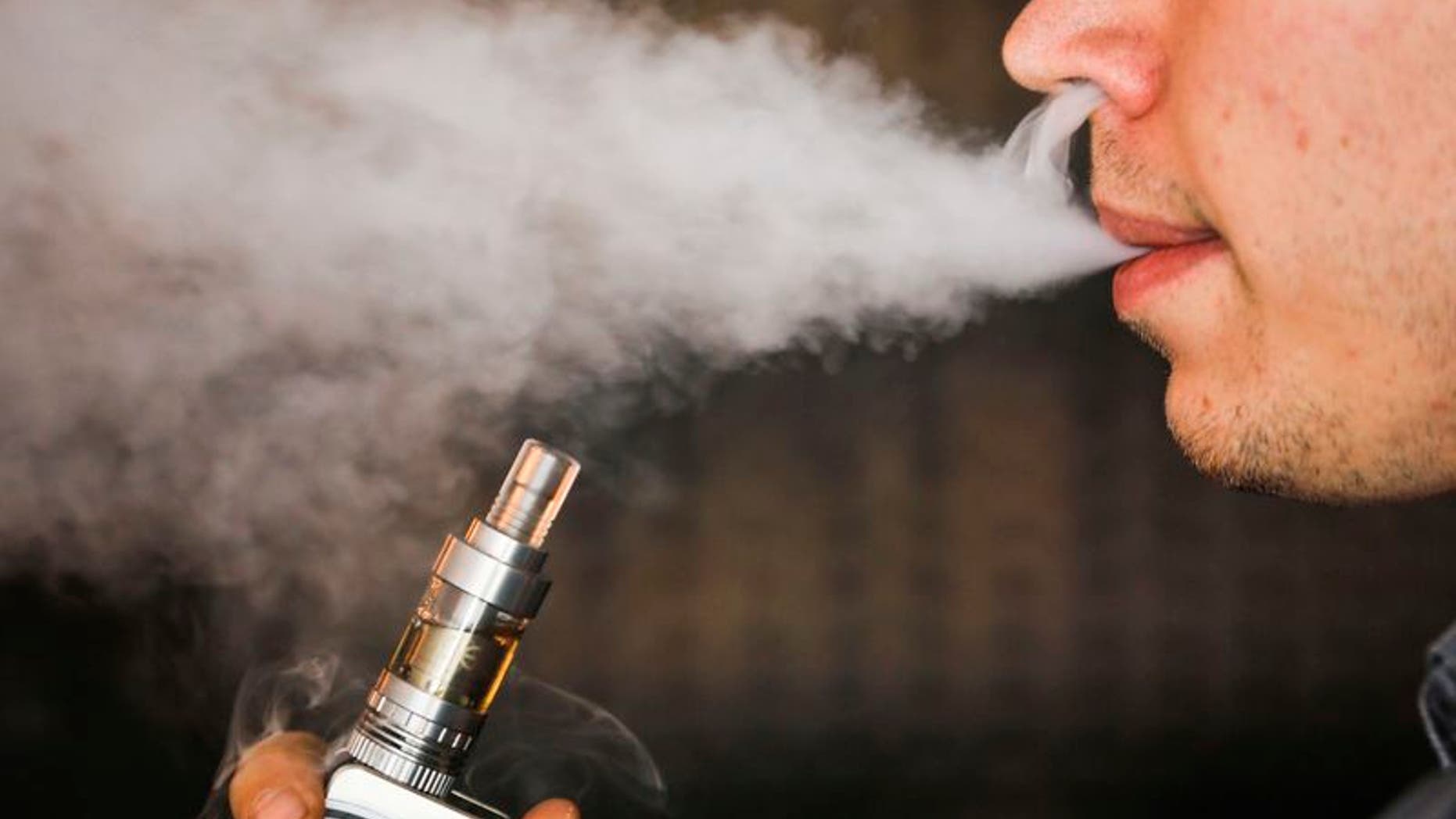 A man smokes an electronic cigarette vaporizer, also known as an e-cigarette, in Toronto, in this August 7, 2015, file photo. REUTERS/Mark Blinch/Files