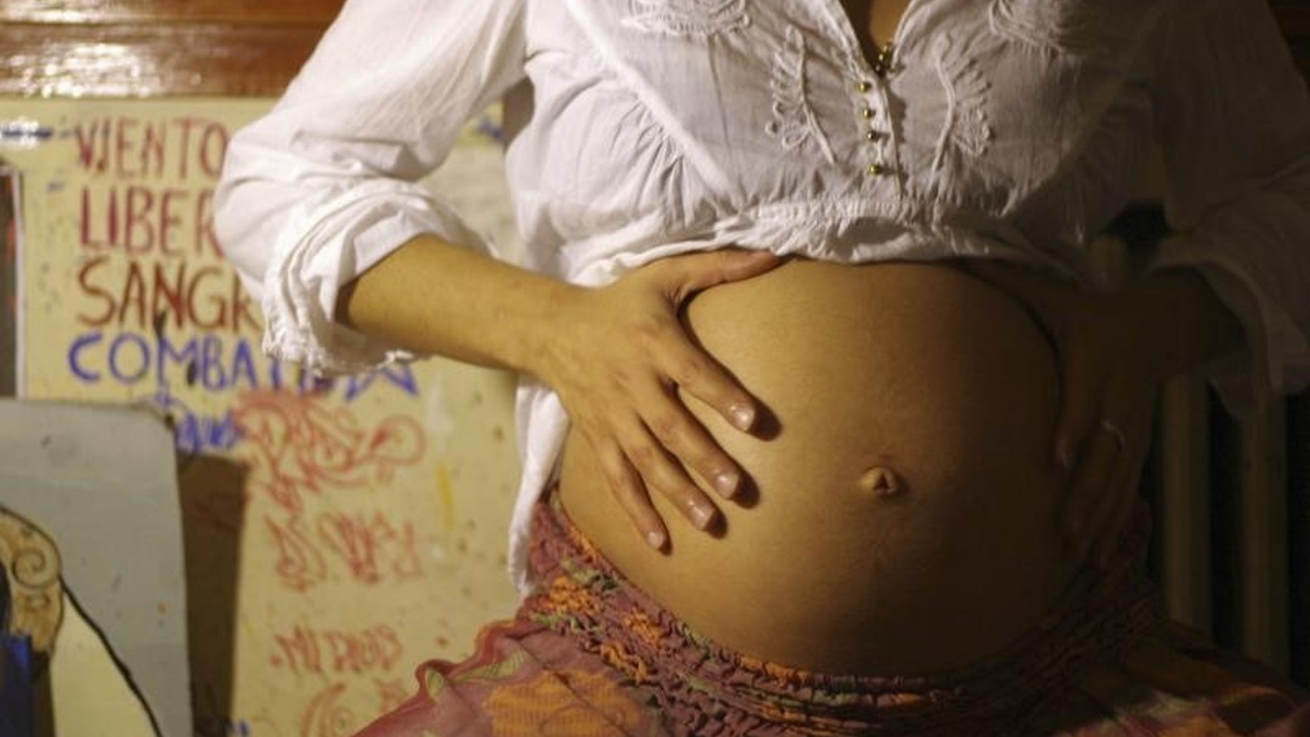 An eight-month pregnant woman touches her stomach at her home in Buenos Aires October 11, 2012. Debate on legalizing abortion has made little headway in Argentina due in part to President Cristina Fernandez's opposition. Catholic leaders condemn abortion under any circumstances and many people share their beliefs. Picture taken October 11, 2012. REUTERS/Stringer (ARGENTINA - Tags: SOCIETY POLITICS) - RTR392OR