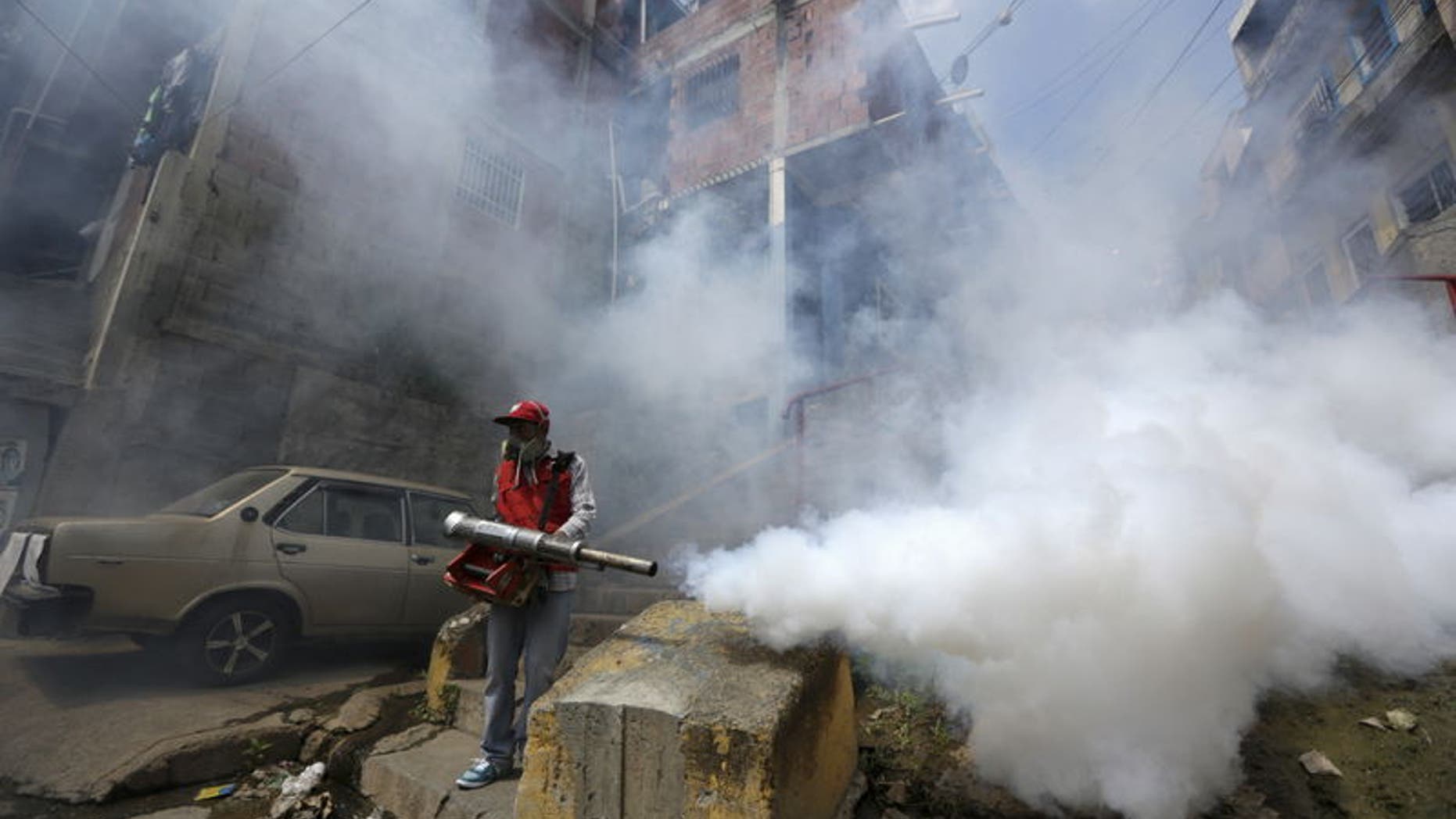 A Venezuelan health worker fumigates the Valle slum to help control the spread of the mosquito-borne Zika virus in Caracas, January 28, 2016. REUTERS/Marco Bello
