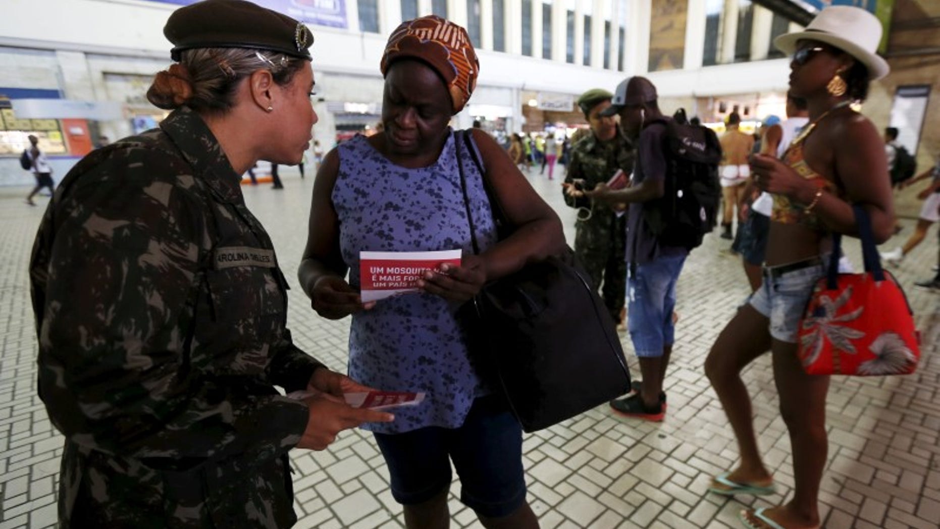 A Brazilian Army soldier distributes pamphlets with information to combat the Aedes aegypti mosquito during the National Day of Mobilization Zika Zero at Central train station in Rio de Janeiro