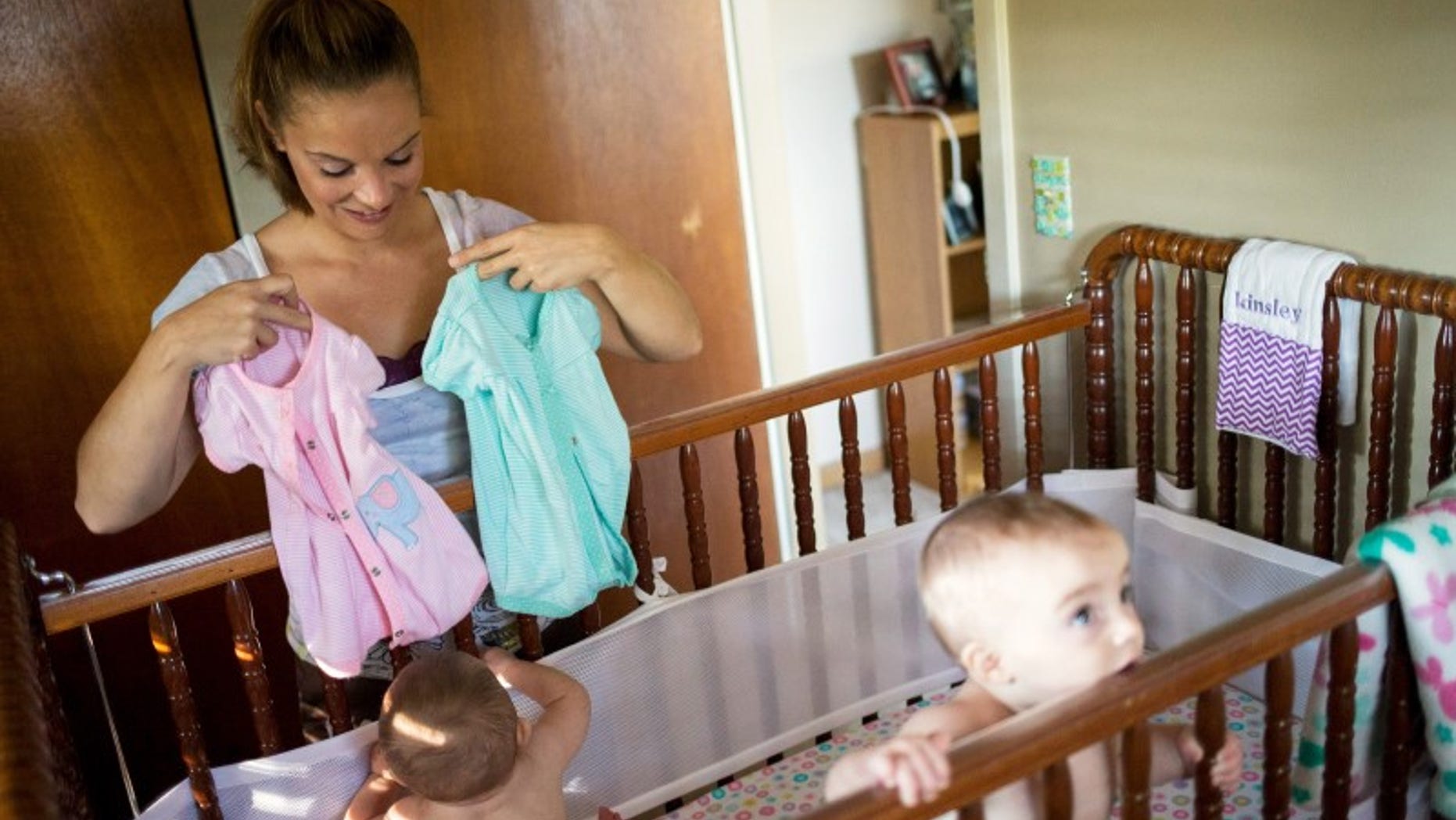 Heather Padgett dresses her daughters Kinsley and Kiley at her home in Cincinnati