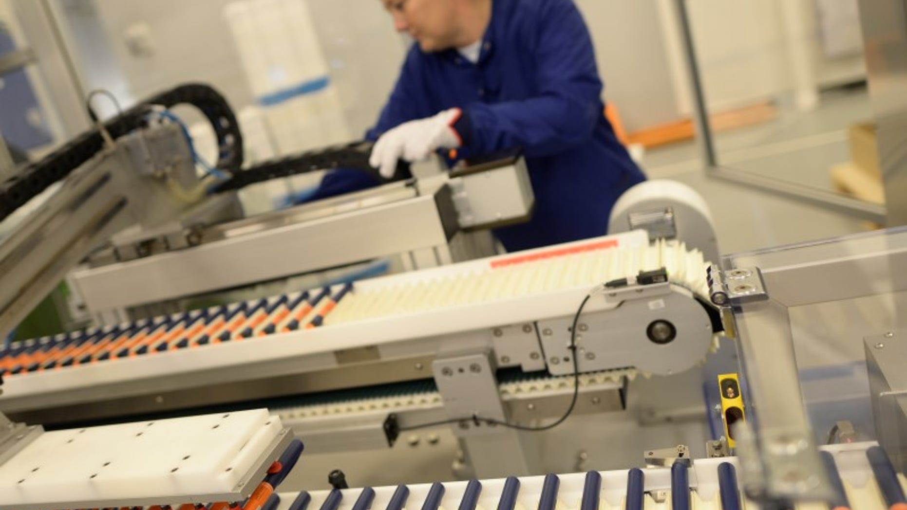 A Novo Nordisk employee controls a machine at an insulin production line in a plant in Kalundborg