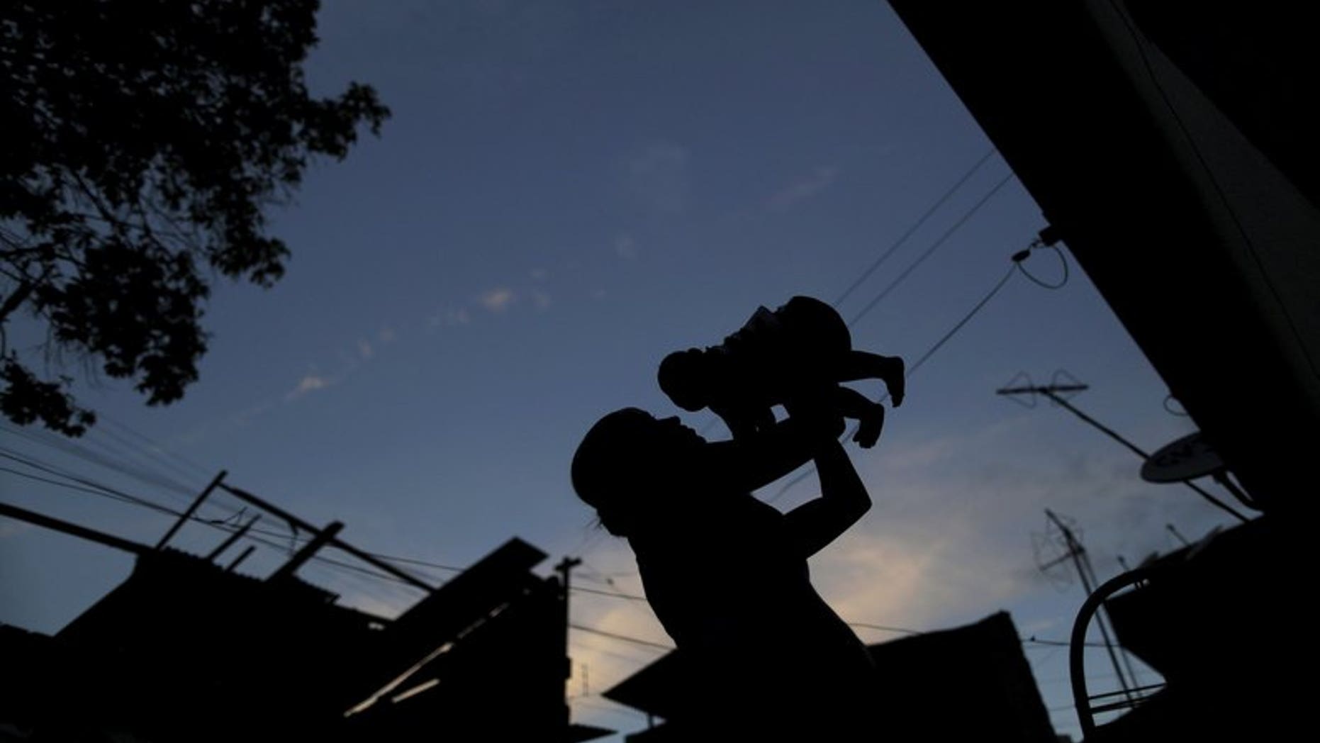 Gleyse Kelly da Silva holds her daughter Maria Giovanna, who has microcephaly, near their house in Recife