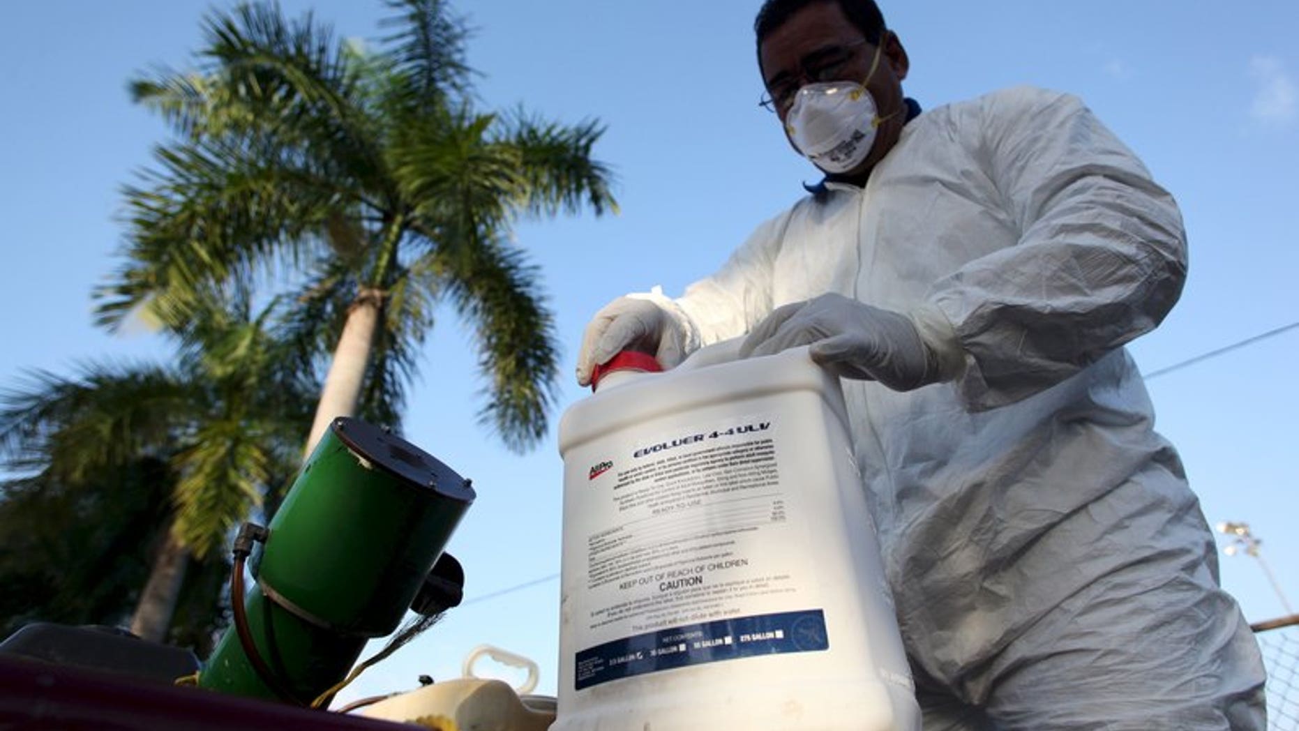File photo of a health worker preparing insecticide before fumigating a neighborhood in San Juan