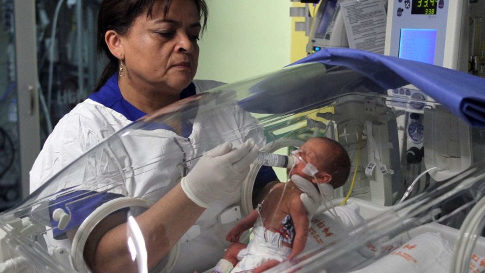 A nurse feeds a newborn baby donated milk during donation day at a hospital in Medellin