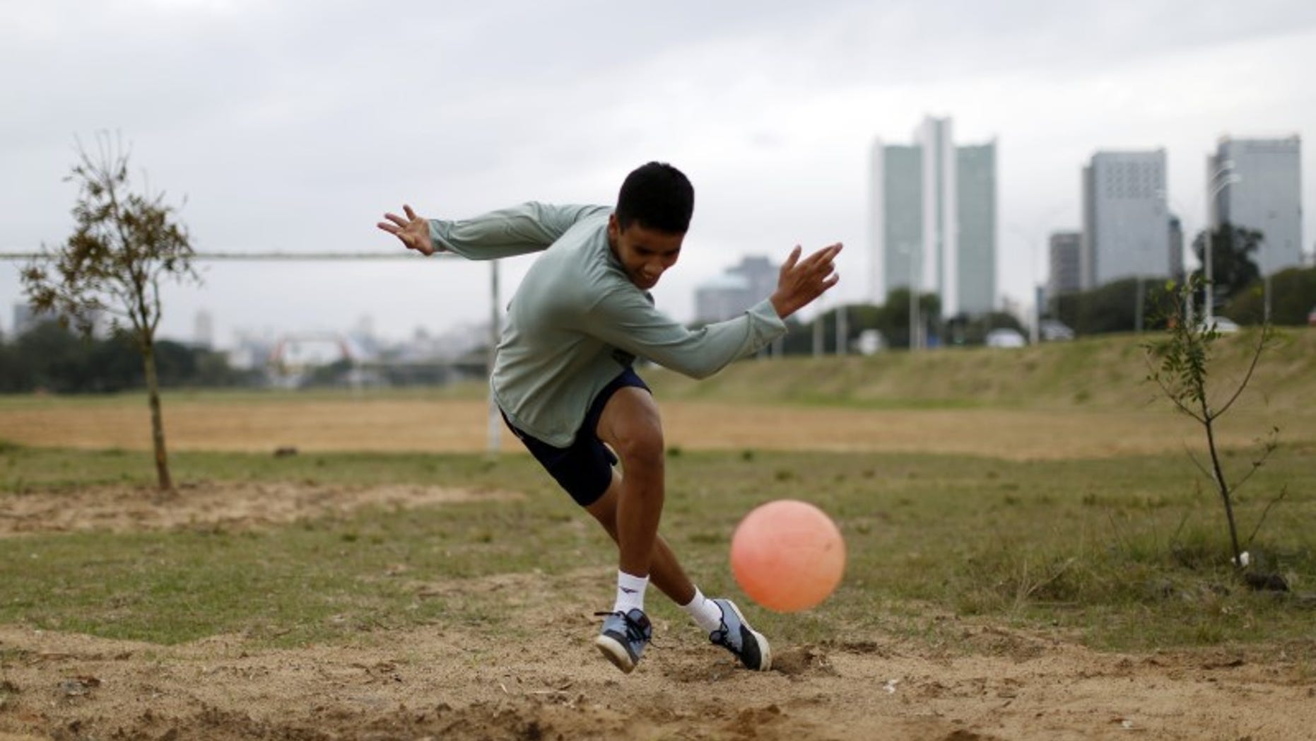 A boy plays soccer in a park in Porto Alegre