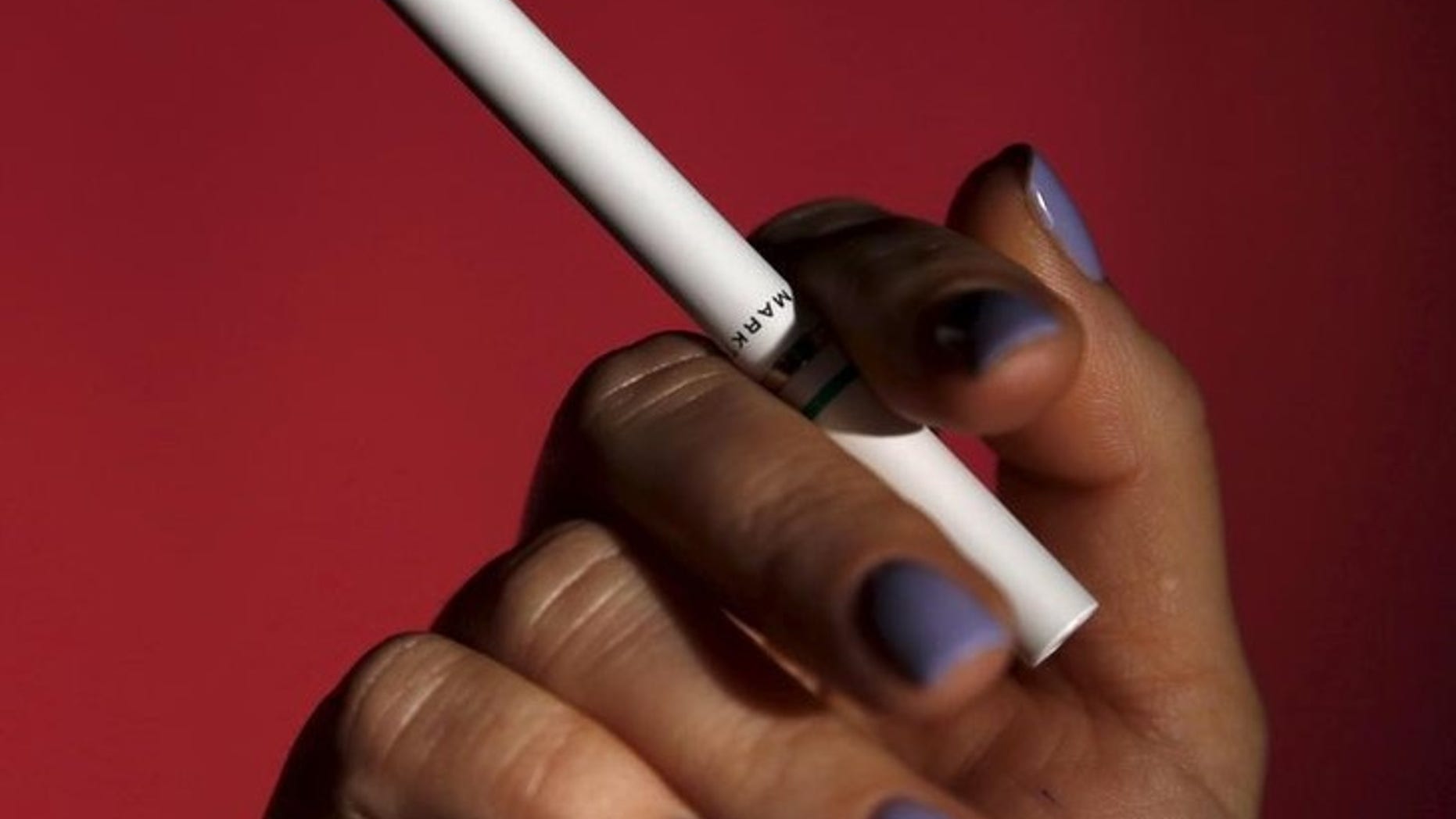 A person holds an electronic MarkTen cigarette as seen in this photo illustration shot in Washington