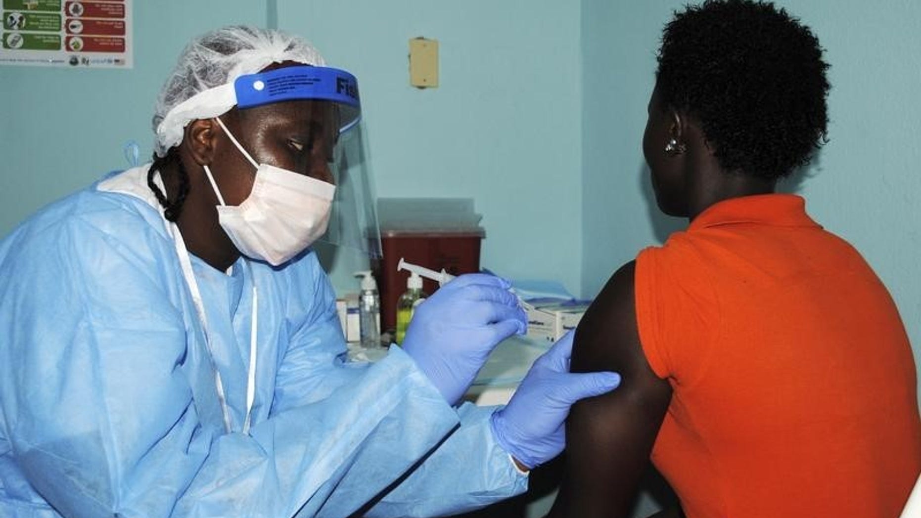 Health worker injects a woman with an Ebola vaccine during a trial in Monrovia