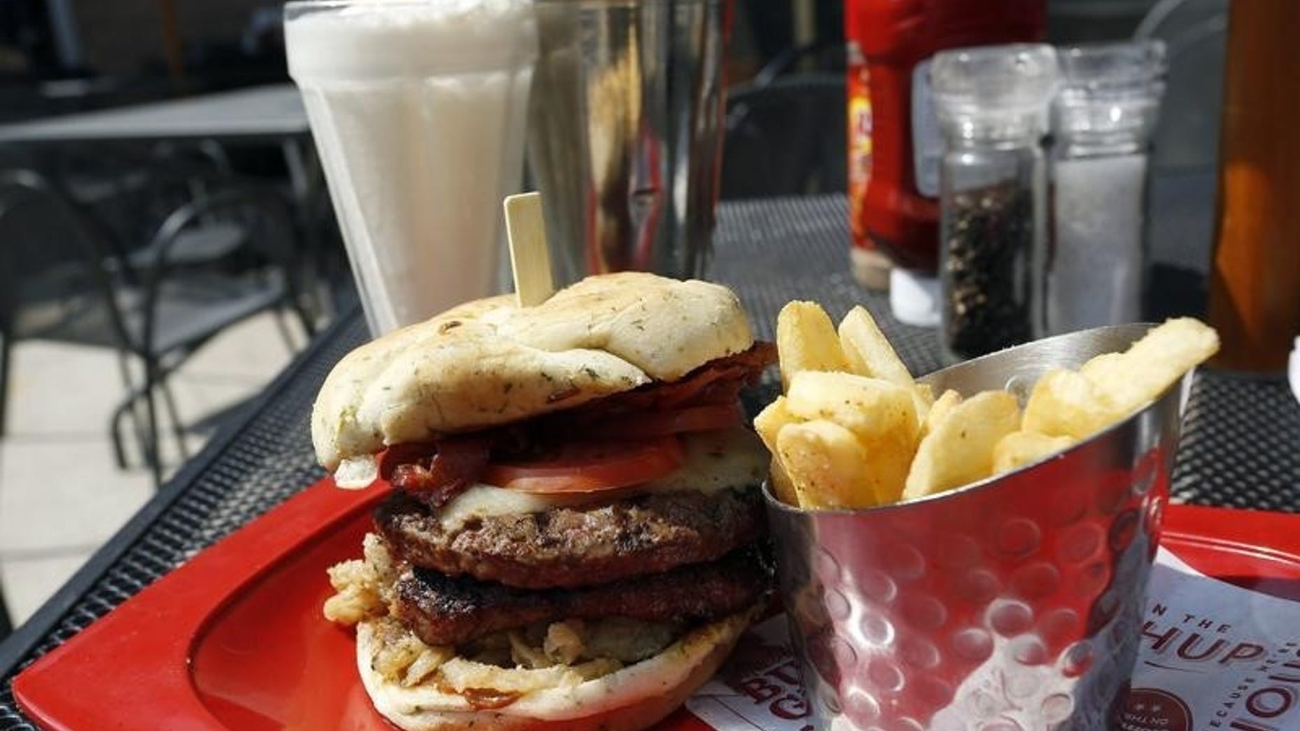 A meal of a "Monster"-sized A.1. Peppercorn burger, Bottomless Steak Fries, and Monster Salted Caramel Milkshake is seen at a Red Robin restaurant in Foxboro