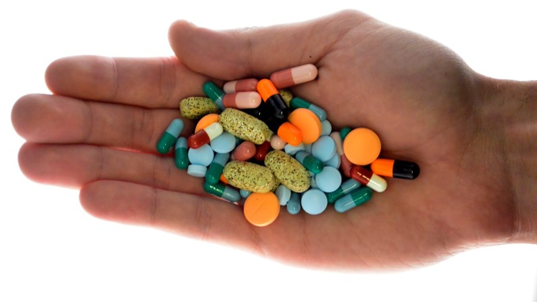 A person holds pharmaceutical tablets and capsules in illustration picture in Ljubljana