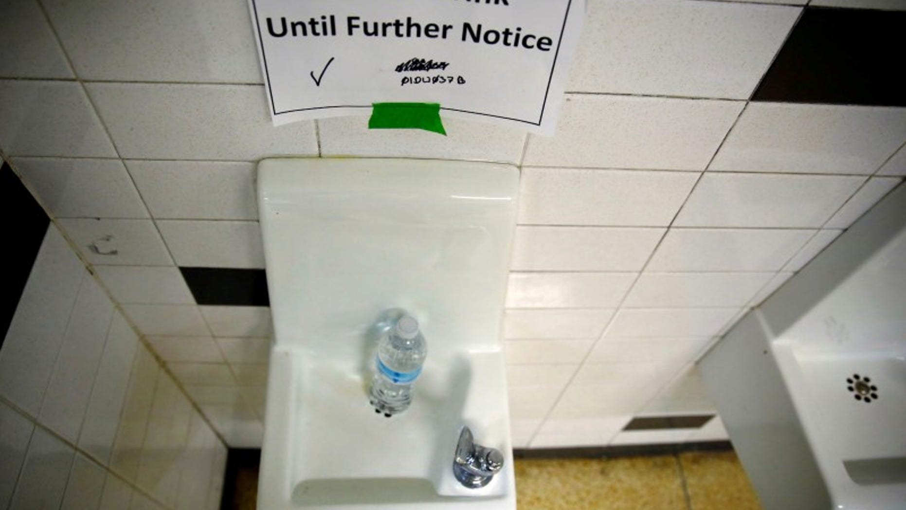A sign is seen next to a water dispenser at North Western High School in Flint, a city struggling with the effects of lead-poisoned drinking water in Michigan