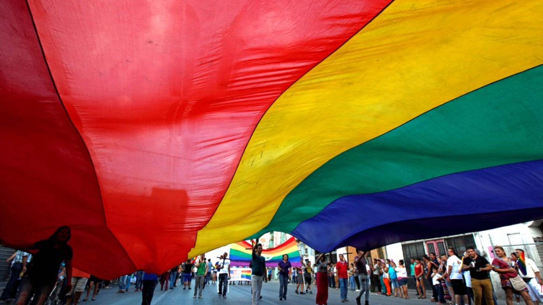 Participants carry a rainbow flag during an annual Gay Pride Parade along the streets of Ciudad Juarez