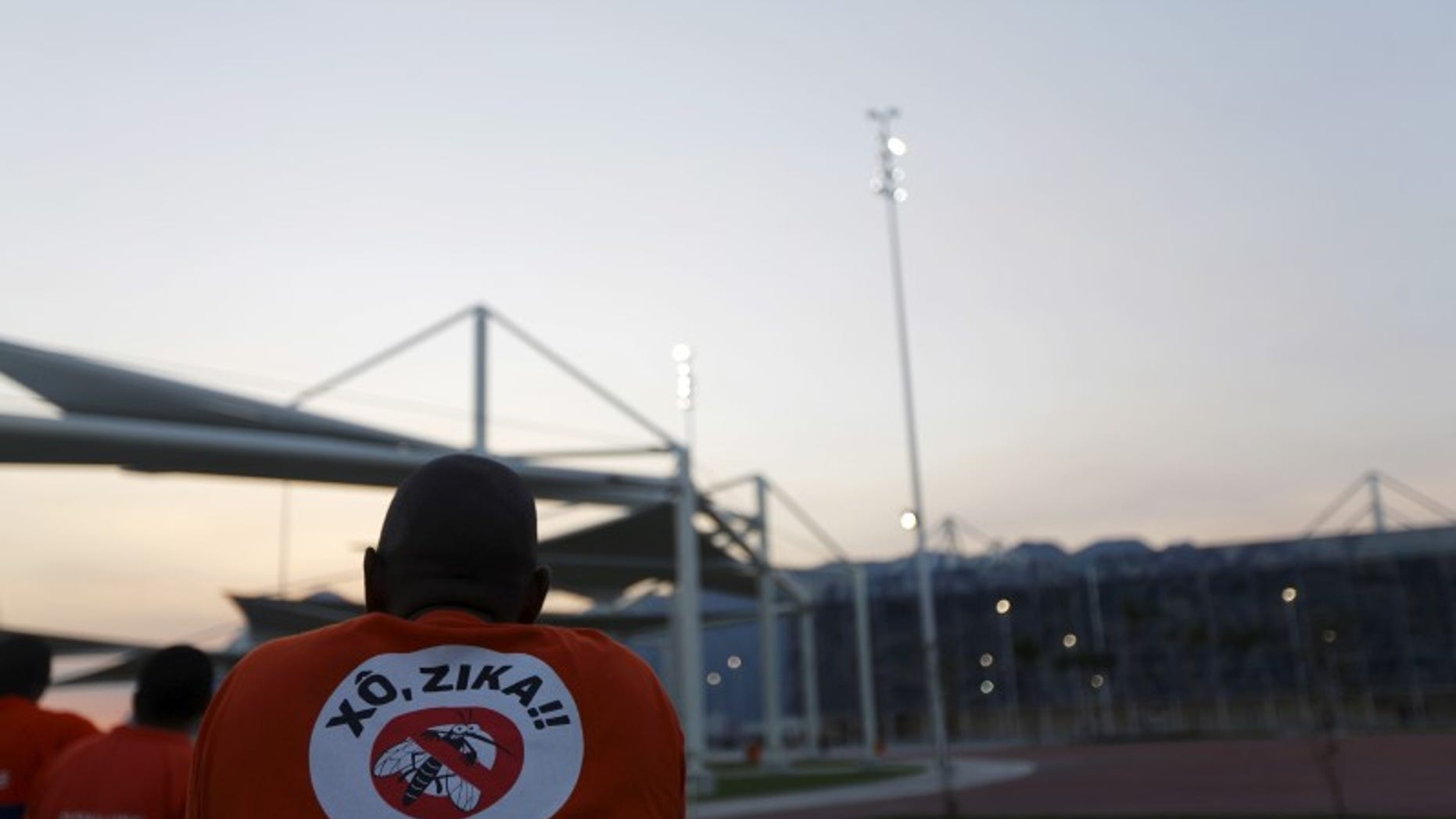 A worker from a public cleaning company wears a T-shirt that reads "Out Zika" is pictured before the inauguration ceremony of the common areas and the Live Site at the 2016 Rio Olympics park in Rio de Janeiro