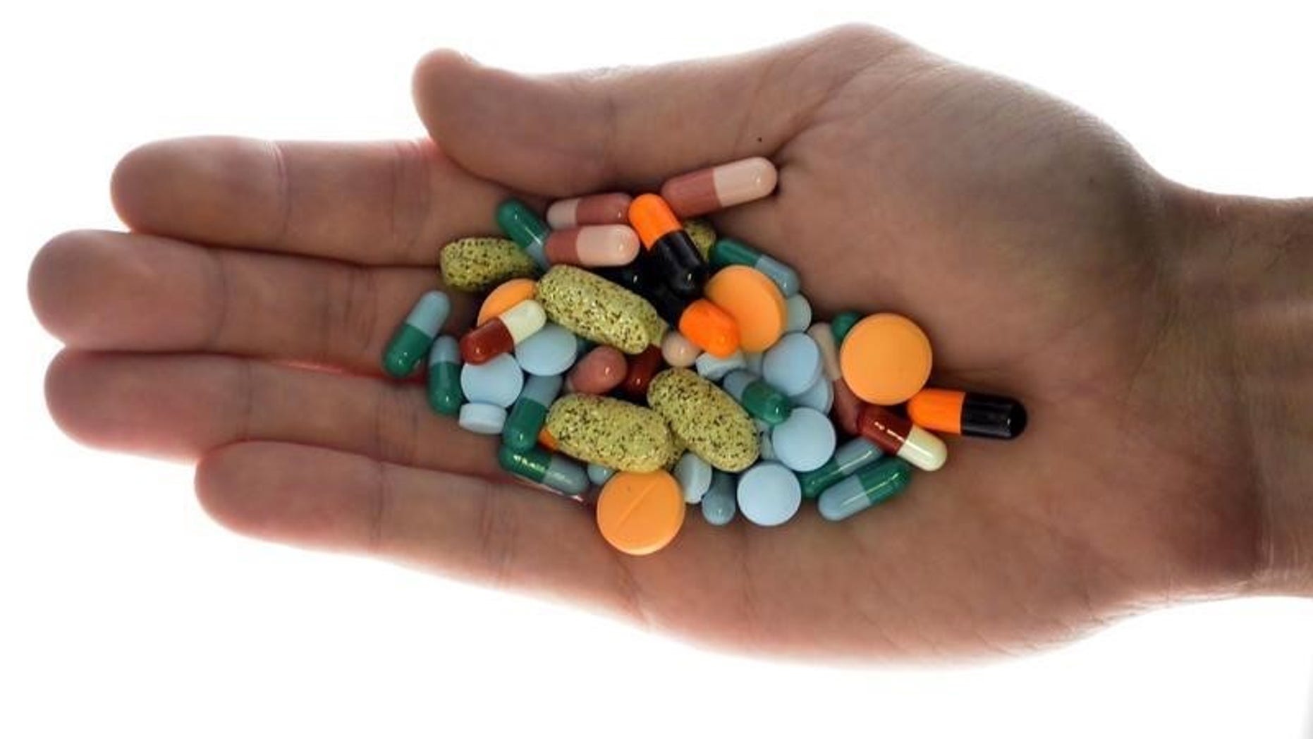A person holds pharmaceutical tablets and capsules in illustration picture in Ljubljana