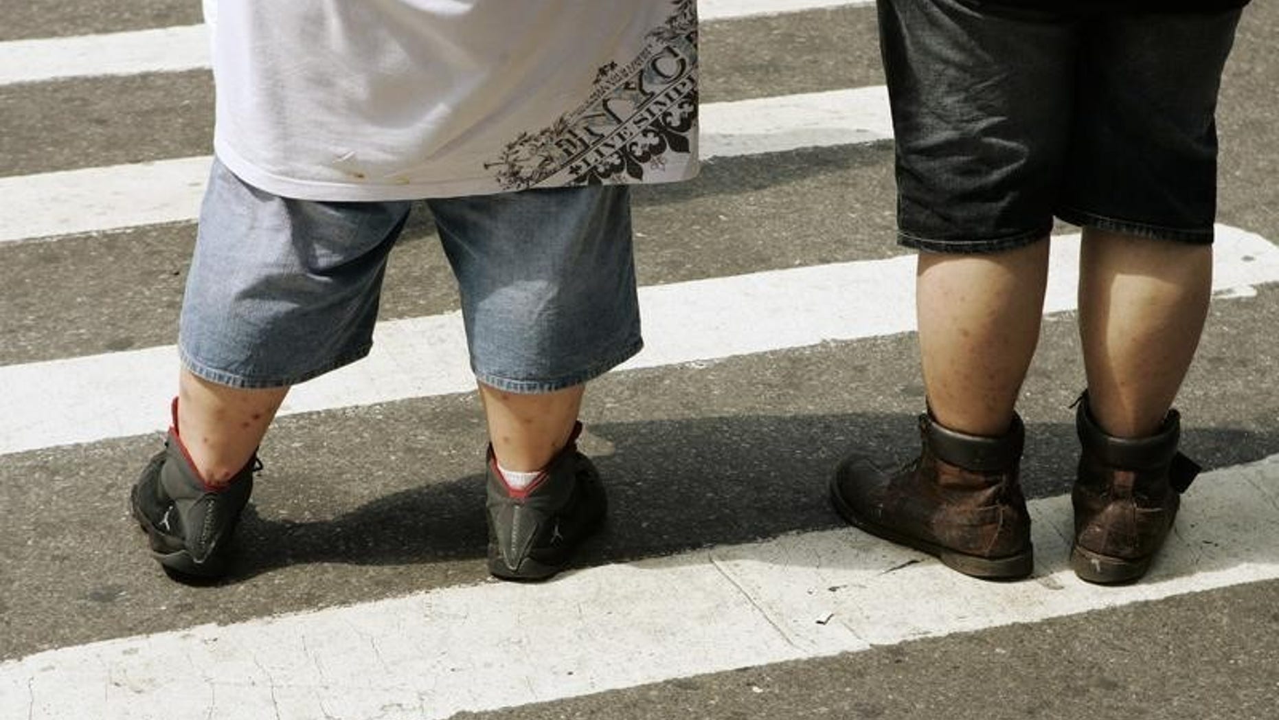 Pedestrians wait to walk across a street near Times Square in New York