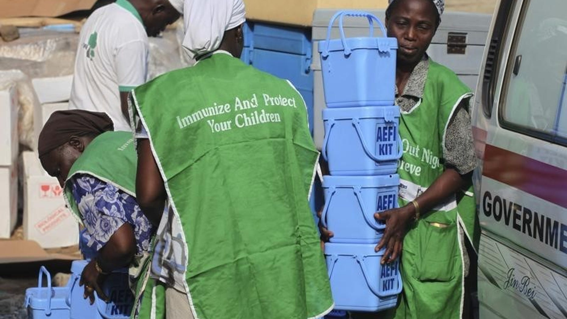Local health workers carry vaccination kits at a distribution centre ahead of the start of a nationwide polio immunization campaign on Wednesday, in Lagos