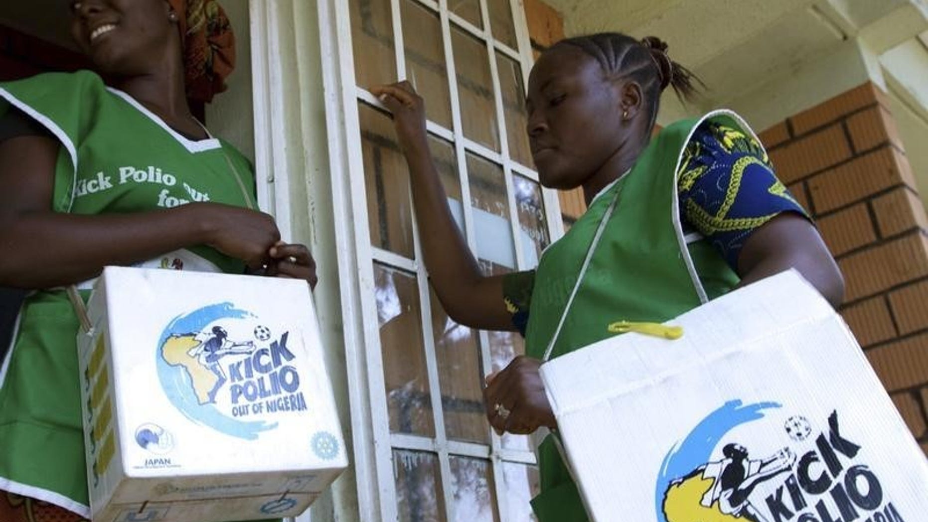 Volunteer Health officials wait to immunise children at a school in Nigeria's capital Abuja