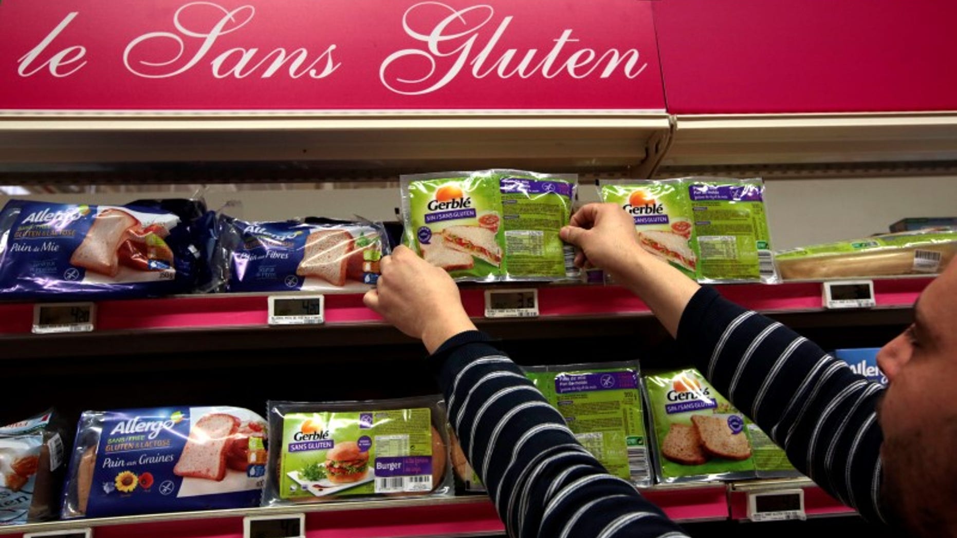 An employee arranges gluten-free products in a supermarket in Nice