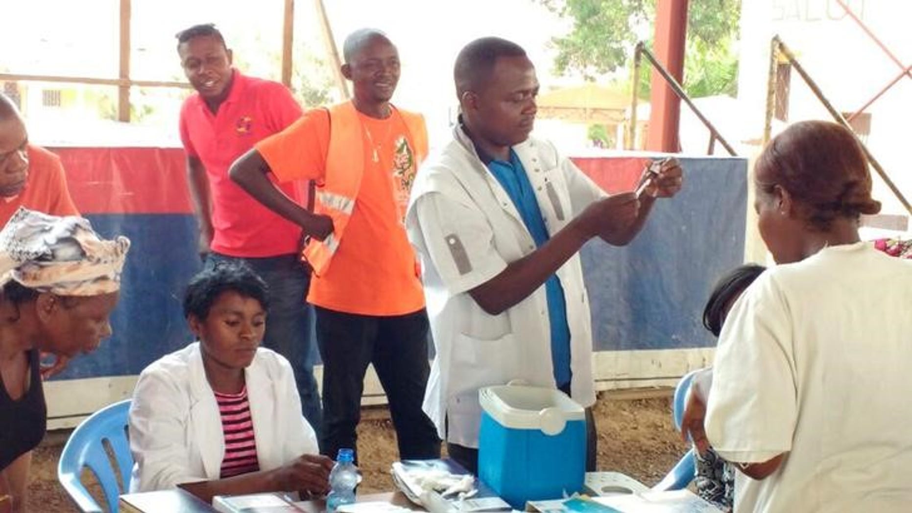 A Congolese health worker prepares to vaccinate a resident against yellow fever outside a church in Gombe district of the Democratic Republic of Congo's capital Kinshasa