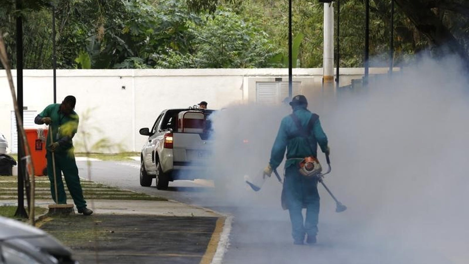 A truck sprays insecticide around Olympic media accomodations in Rio de Janeiro