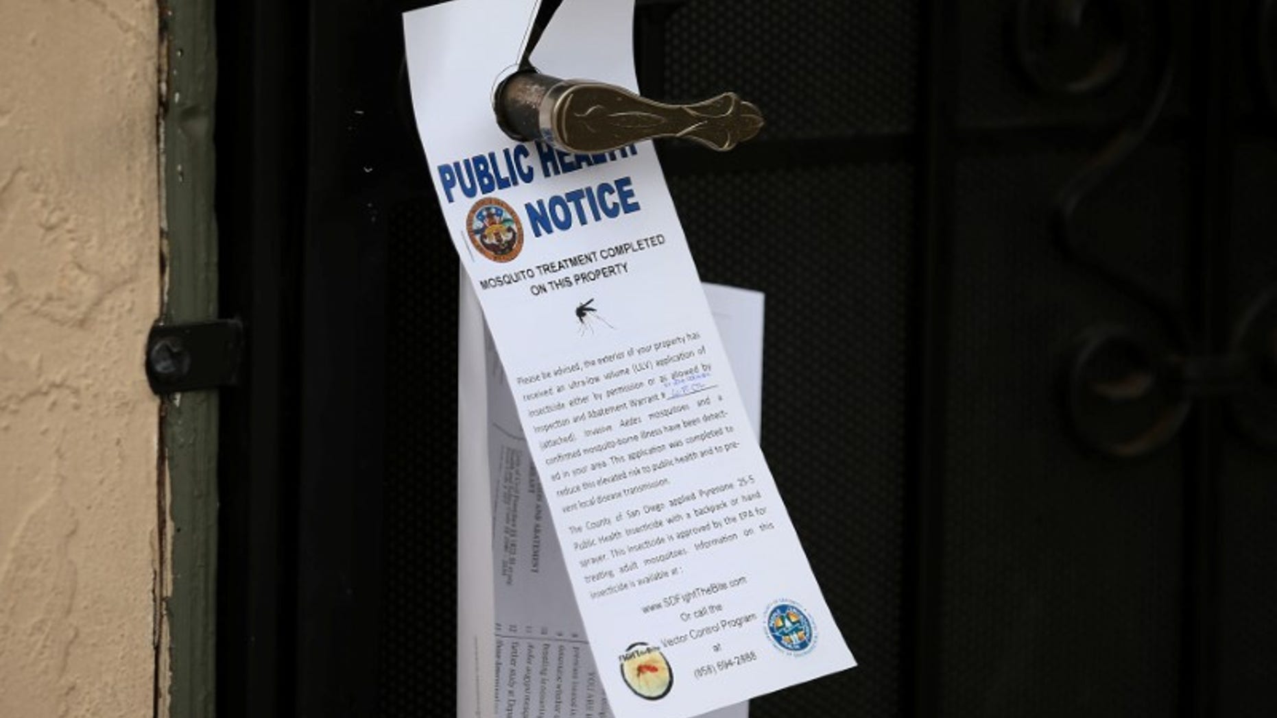County vector control leave information on door handles as they hand-spraying a neighborhood for adult Aedes mosquitoes after a travel-related case of Zika was confirmed in this the area of San Diego