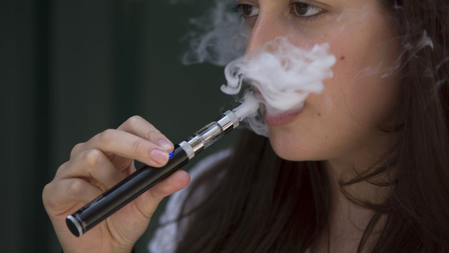 A woman smokes an electronic cigarette in London