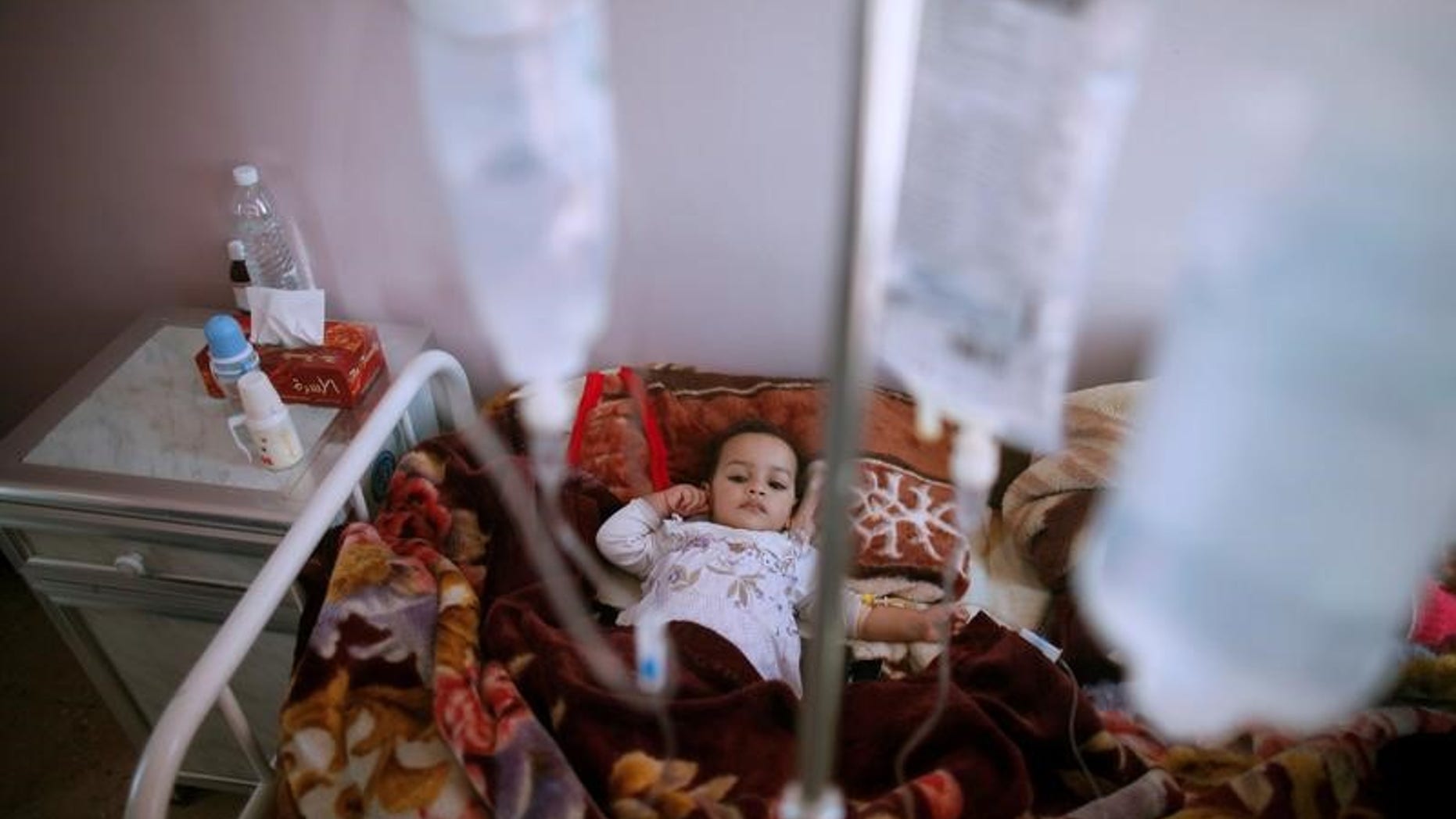 A girl lies on a bed at a cholera treatment center in Sanaa, Yemen