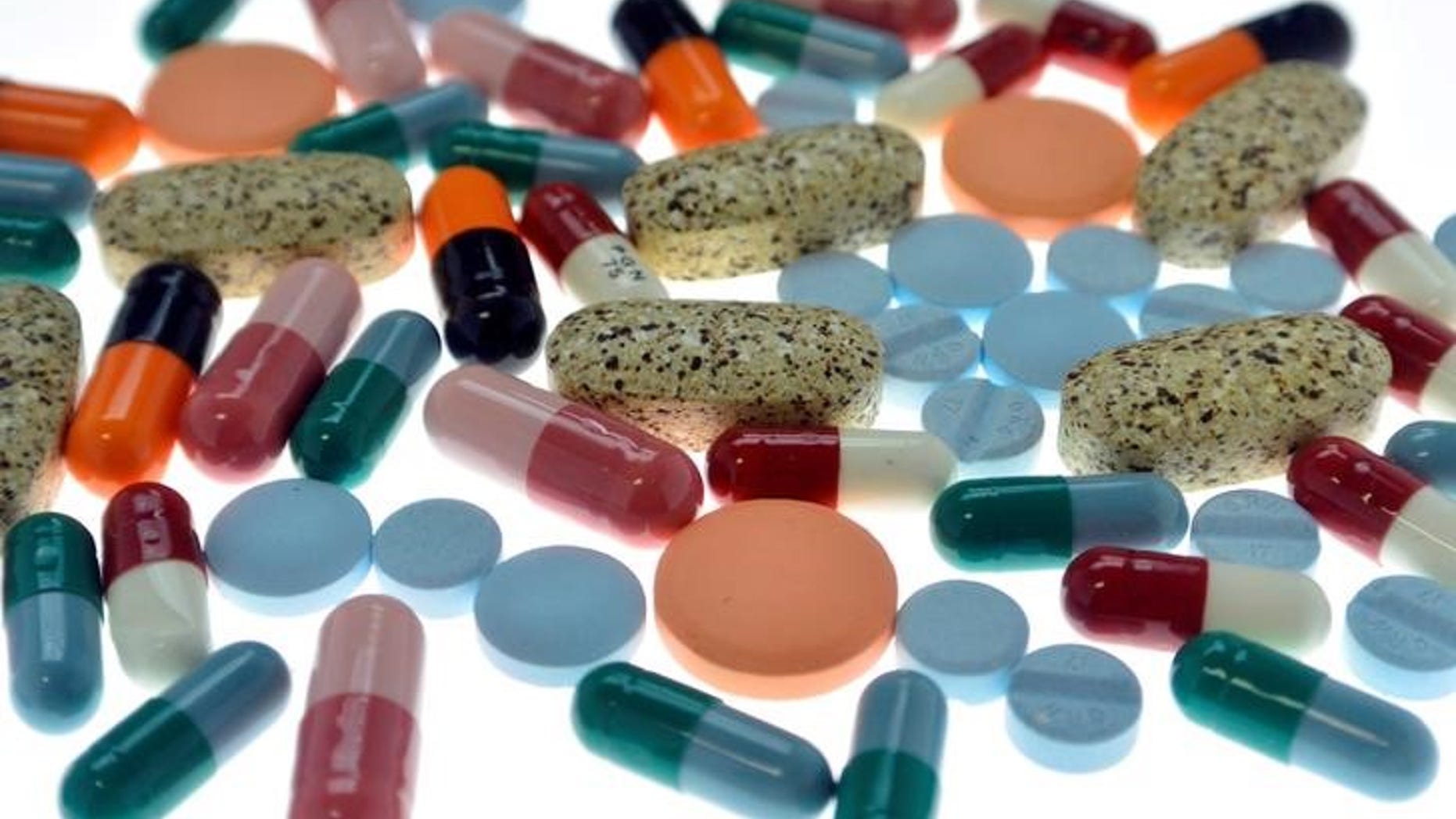 Pharmaceutical tablets and capsules are arranged on table in photo illustration