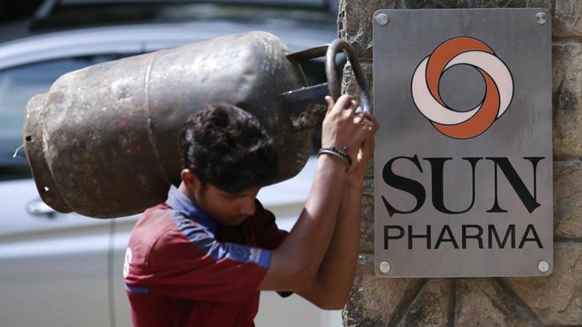 A man carrying gas cylinder walks out of research and development centre of Sun Pharmaceutical Industries Ltd in Mumbai