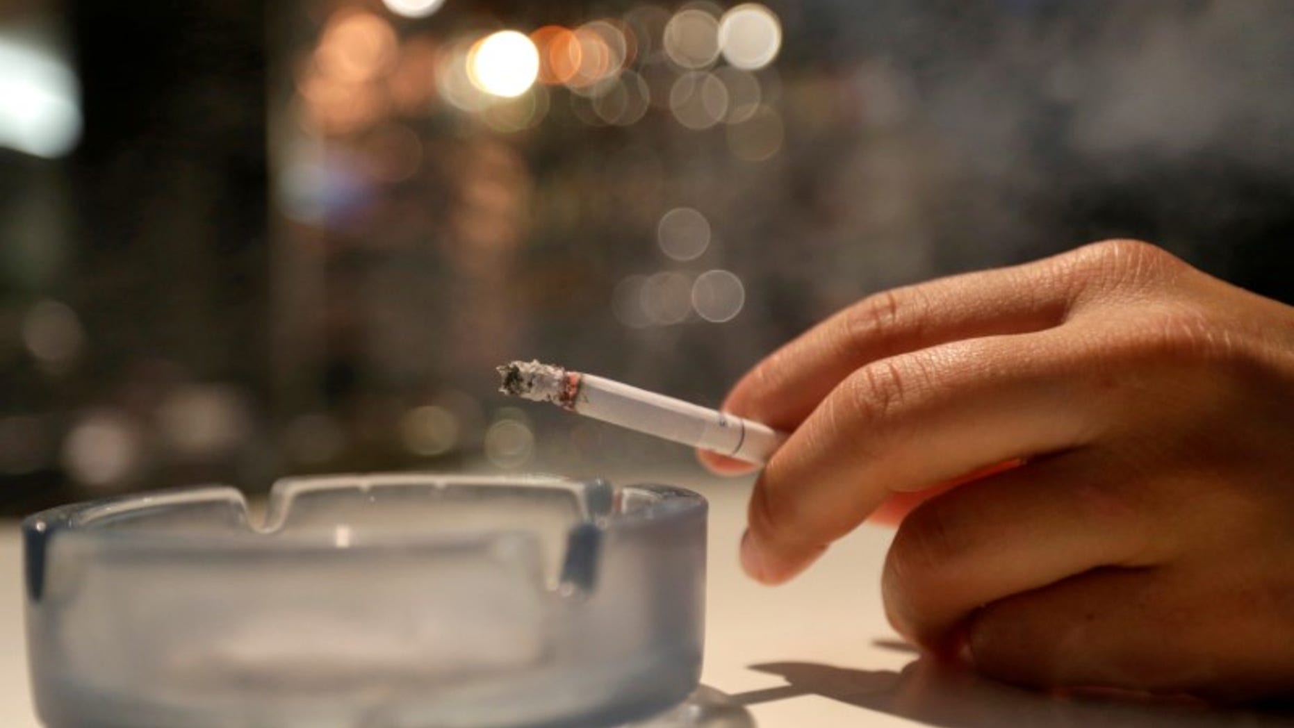 A customer smokes a cigarette in a cafe in Prague