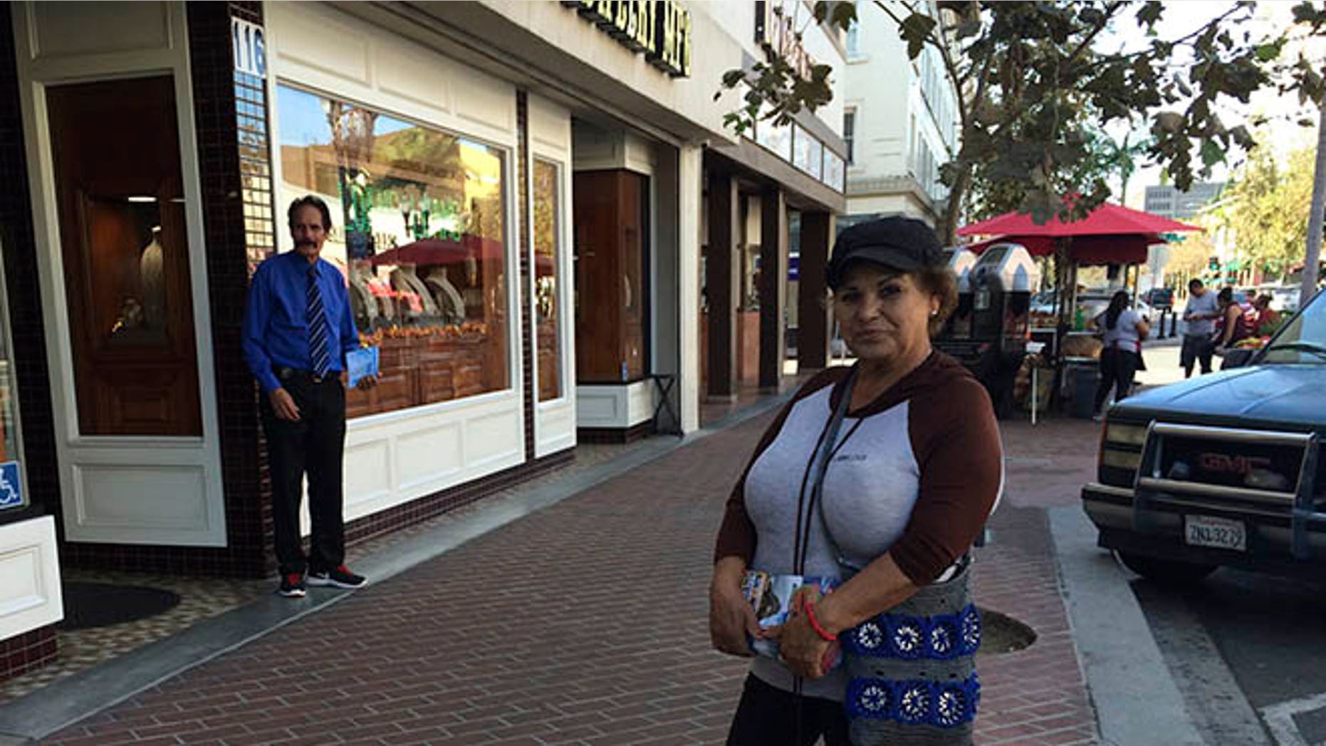 Alicia Ramirez, 67, hands out fliers to passers-by on a busy street in a largely Latino area lined with money transfer businesses and shops selling elegant gowns for quinceanera celebrations, on Wednesday, Nov. 9, 2016, in Santa Ana, Calif. She said she's afraid of what a Trump victory will mean for immigrants like her who lack legal papers. (AP Photo/Amy Taxin)