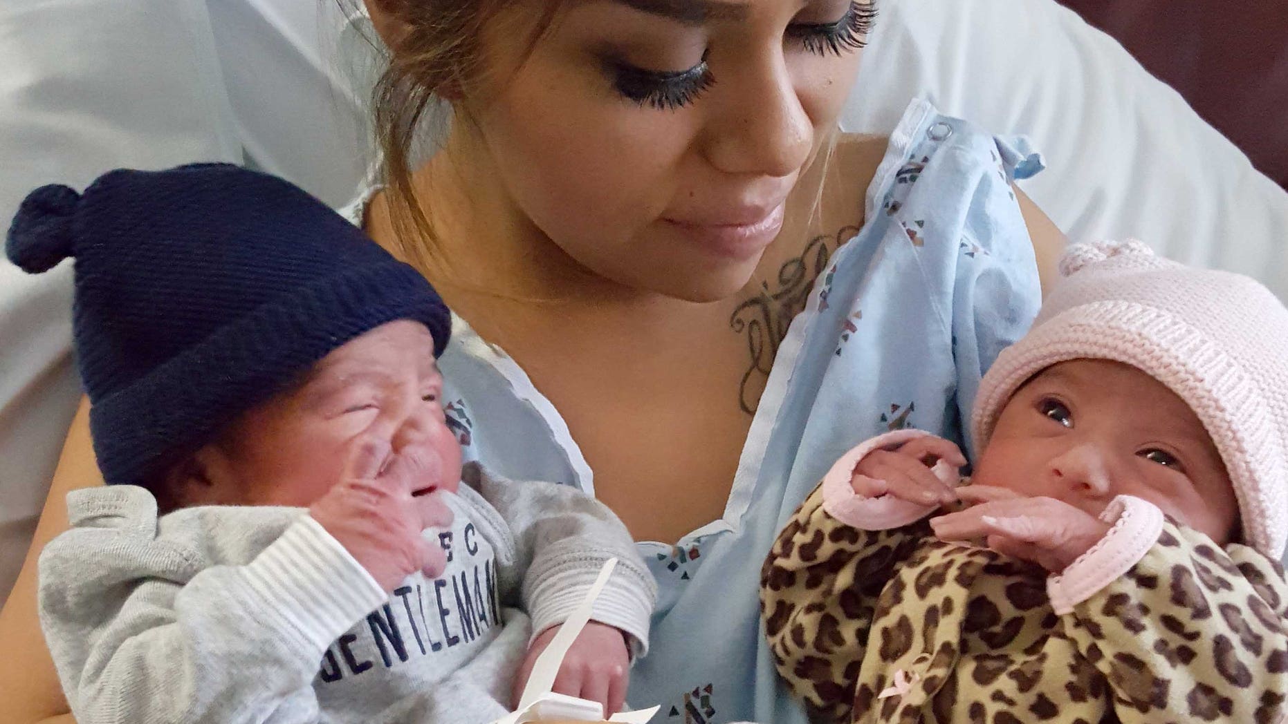 This Jan. 1, 2016 photo provided by Kaiser Permanente San Diego shows Maribel Valencia holds her newborn twins at the San Diego Kaiser Permanente Zion Medical Center in San Diego. Jaelyn, right, and Luis Salgado, who were born just minutes apart, but in different years. Jaelyn was born in the last minute of New Year's Eve 2015 and Luis in the first few minute of New Year's Day 2016. (Kaiser Permanente San Diego via AP)