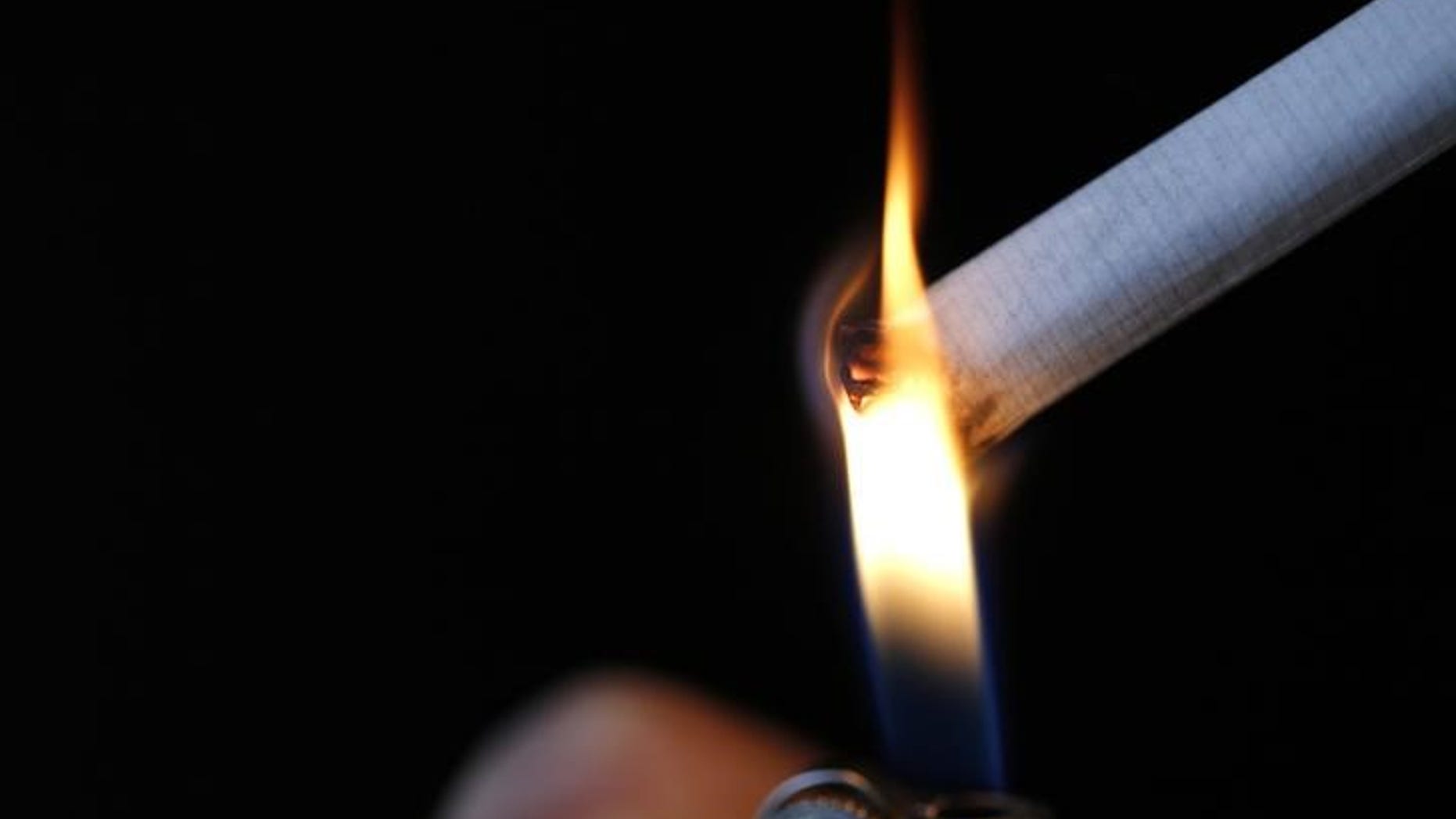 A woman lights a cigarette in this illustration picture taken in Paris