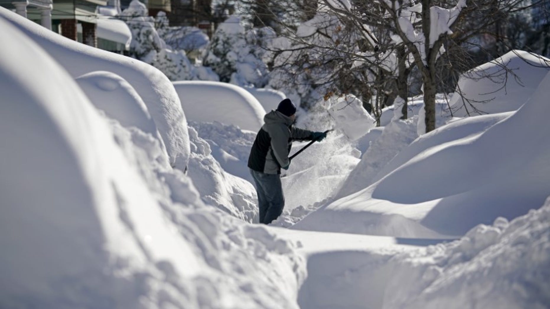A resident shovels snow away from the entrance to his home in Union City
